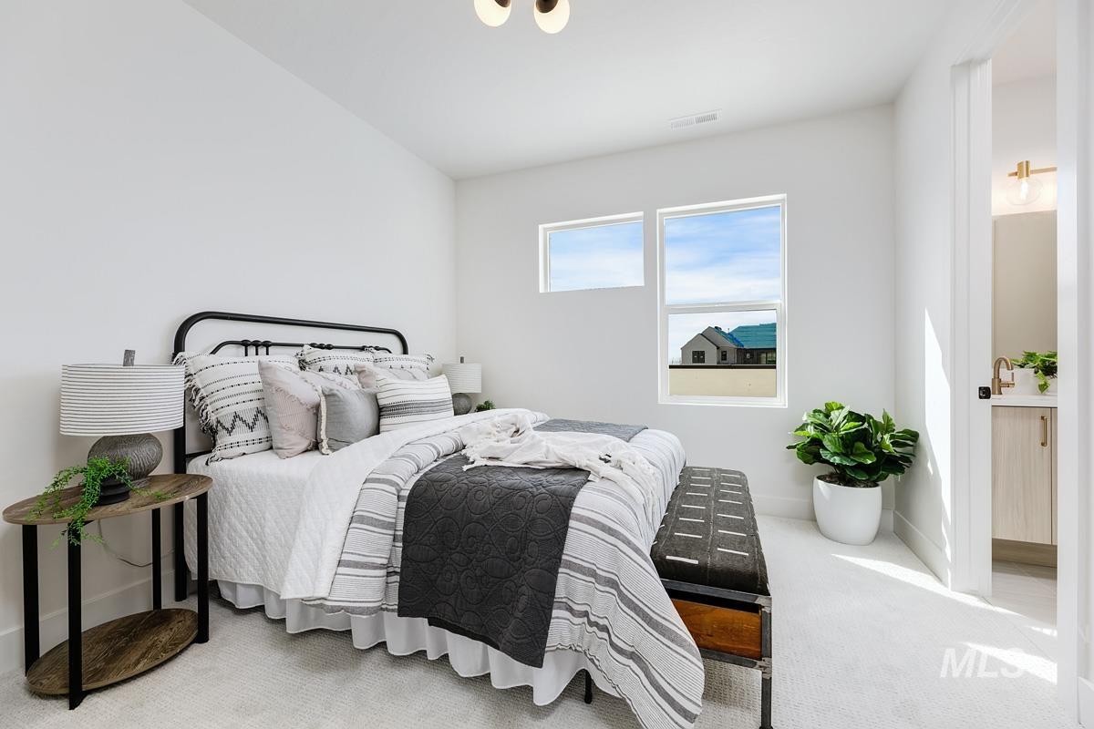 Carpeted bedroom featuring baseboards and ensuite bathroom