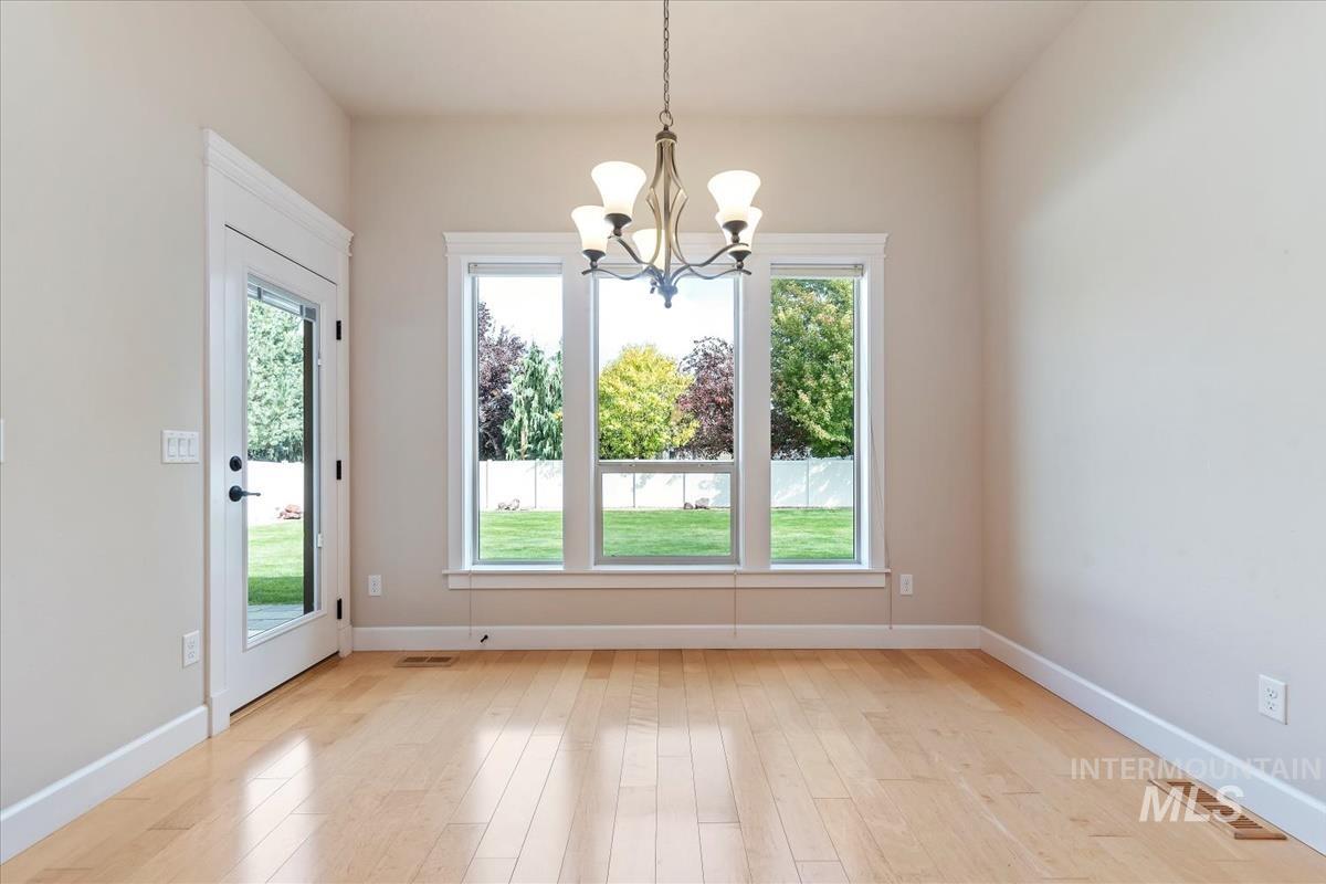 Unfurnished dining area featuring light wood-type flooring and a chandelier