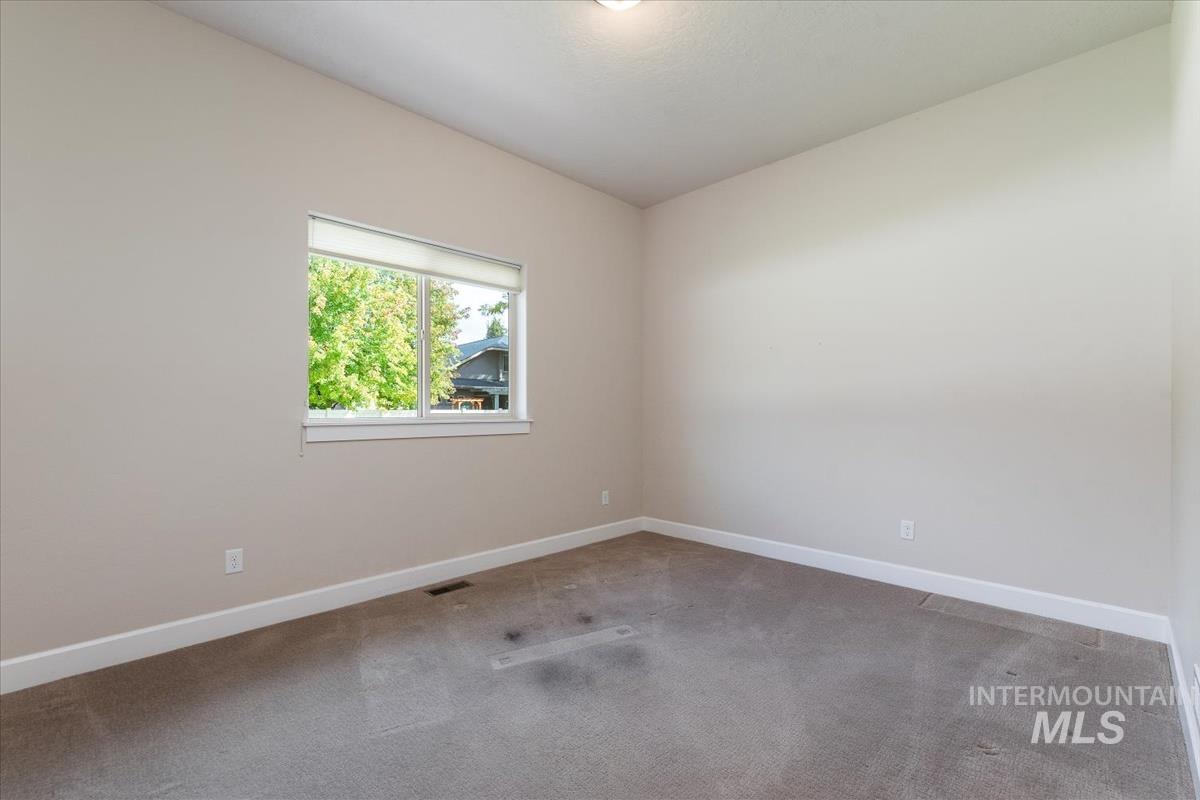 Spare room with carpet and baseboards