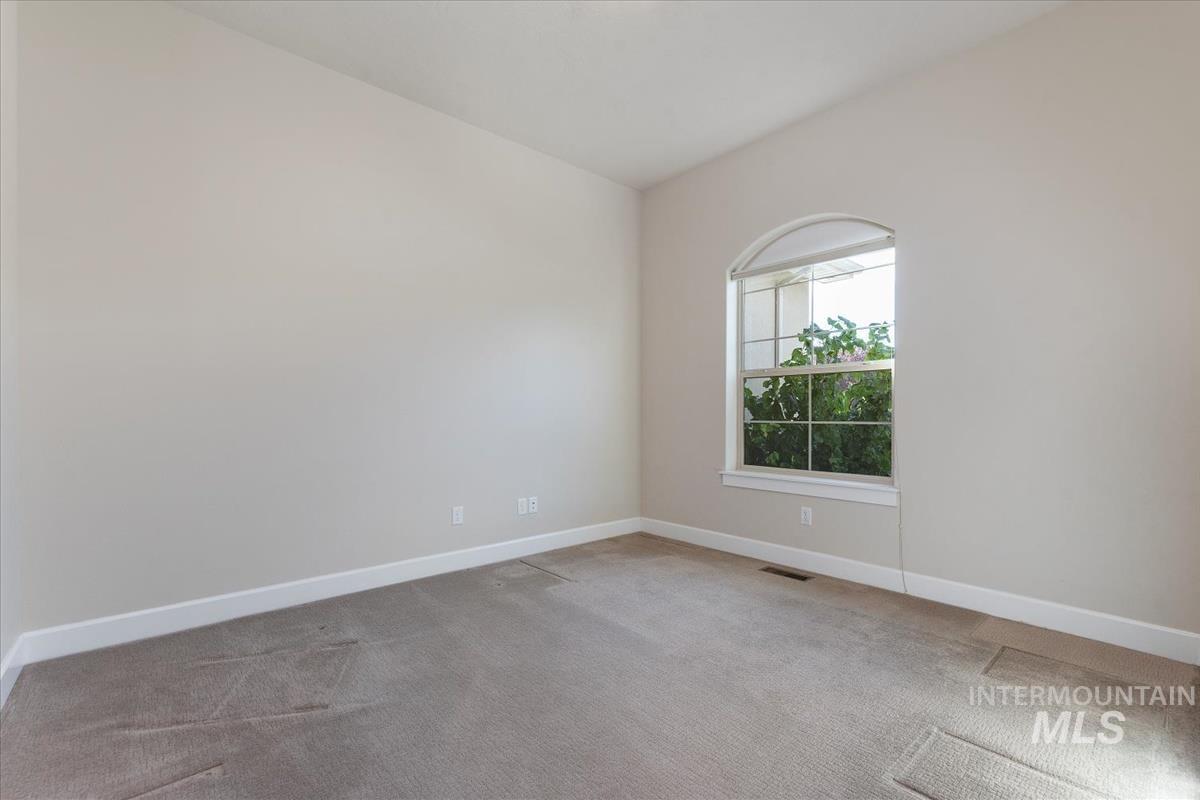 Empty room featuring light colored carpet and baseboards