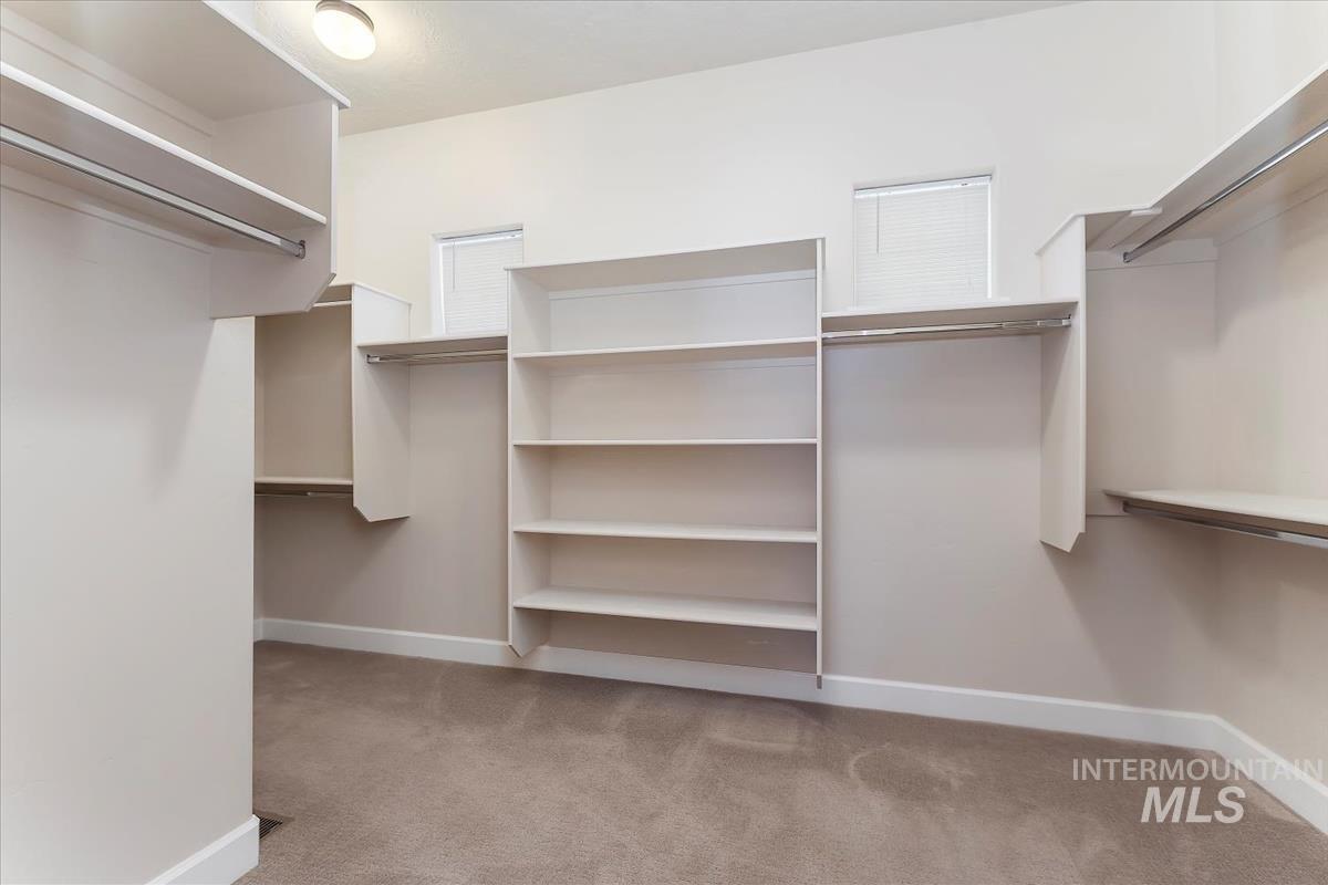 Walk in closet featuring light colored carpet