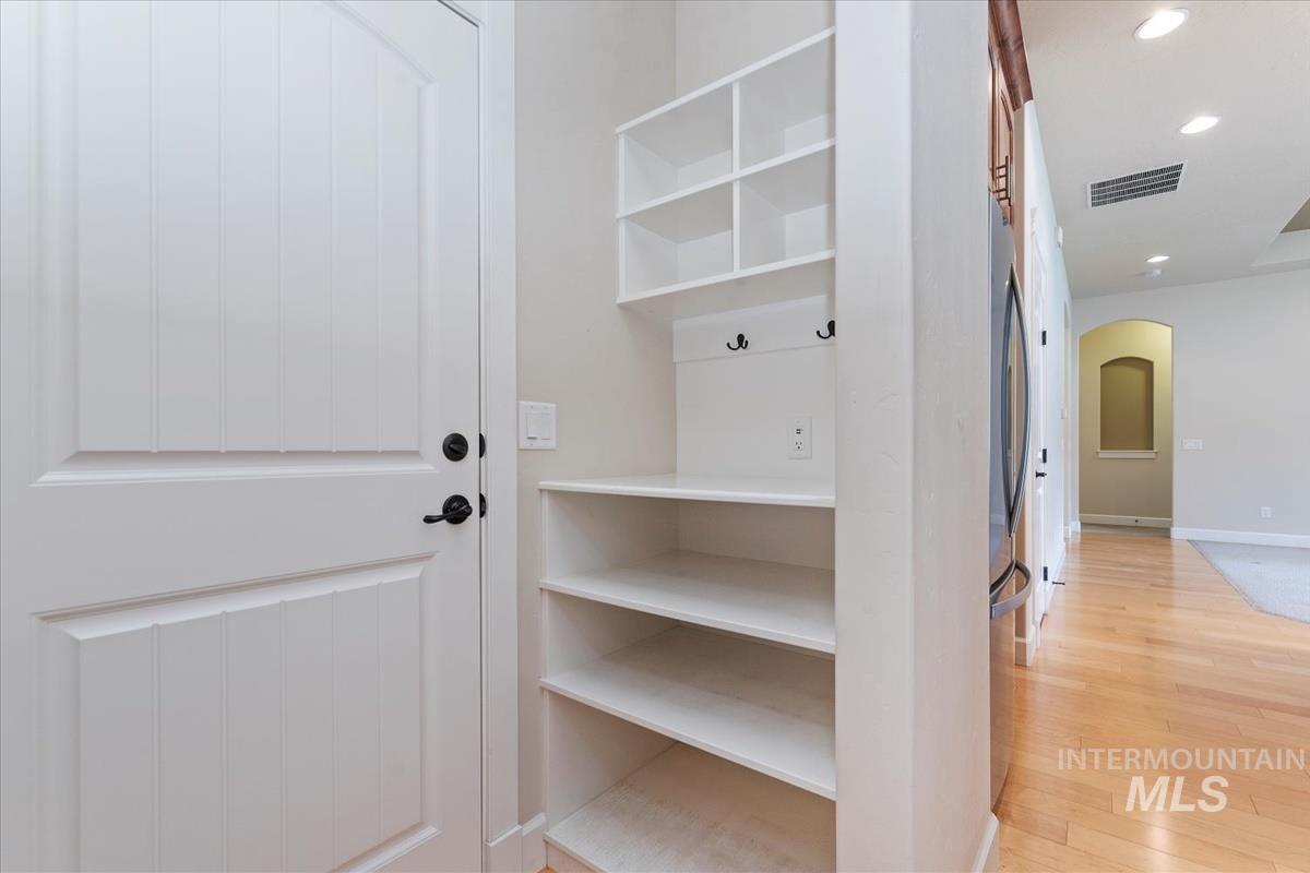 Mudroom featuring arched walkways, light wood-type flooring, and recessed lighting