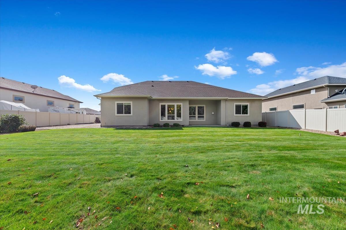 Rear view of property with a fenced backyard, stucco siding, and a patio
