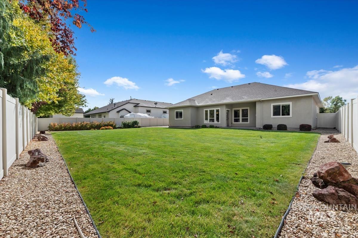 Rear view of house featuring a fenced backyard, stucco siding, and a patio