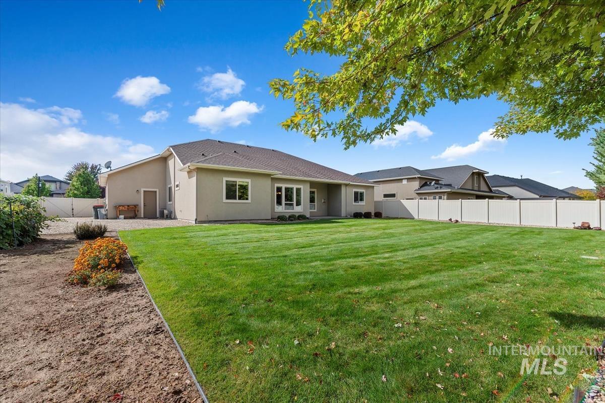 Back of property featuring a fenced backyard and stucco siding
