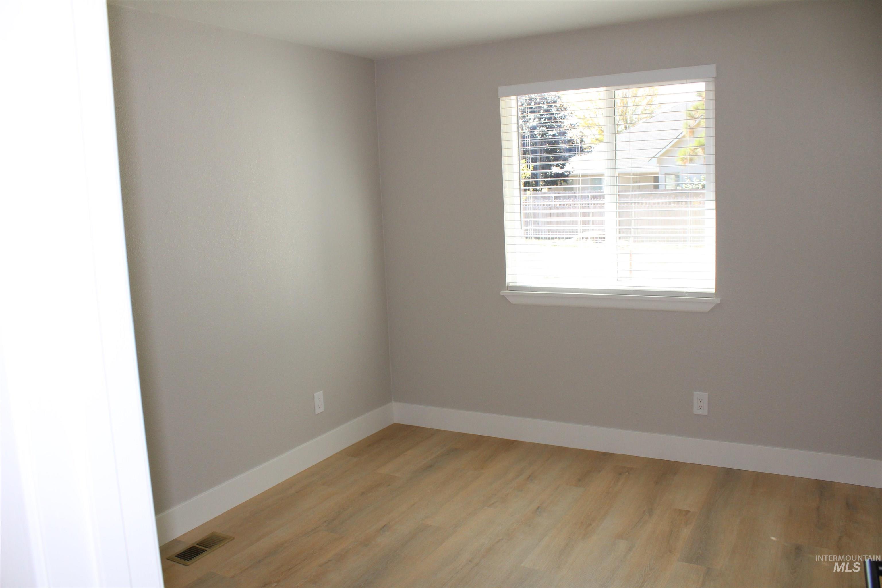 Spare room with baseboards and light wood finished floors
