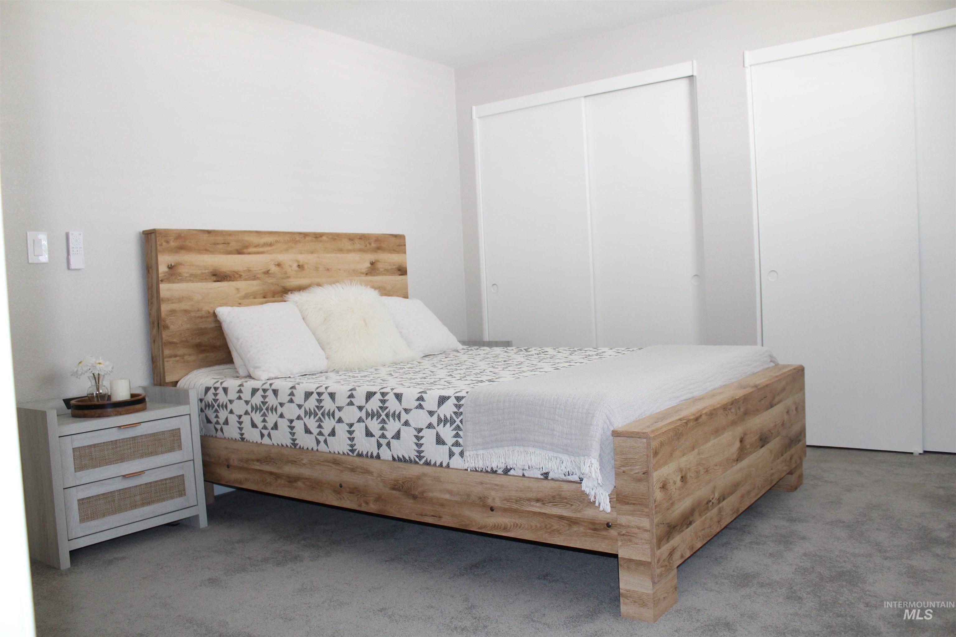 Carpeted bedroom featuring multiple closets