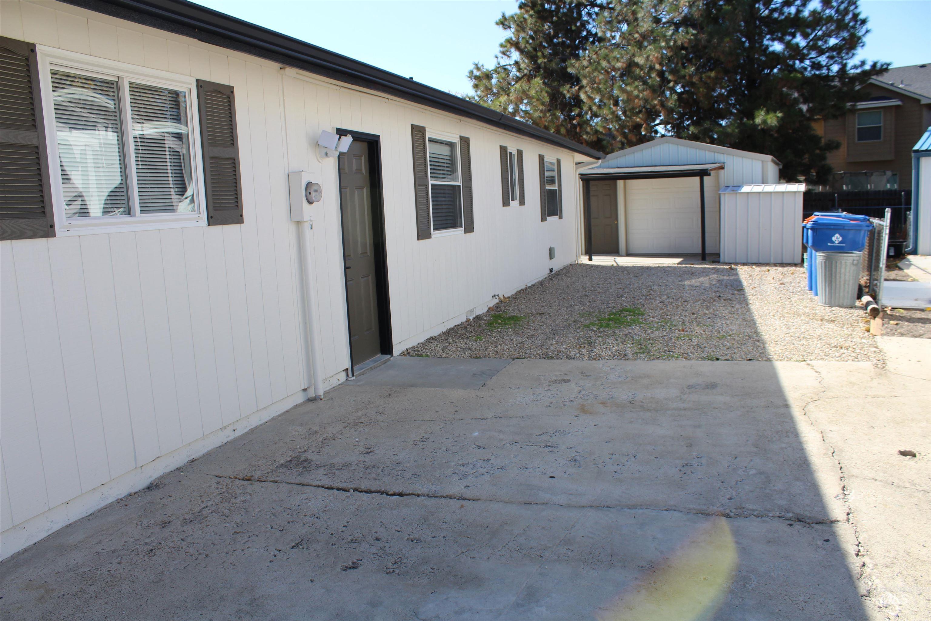 View of side of property featuring an outdoor structure and driveway
