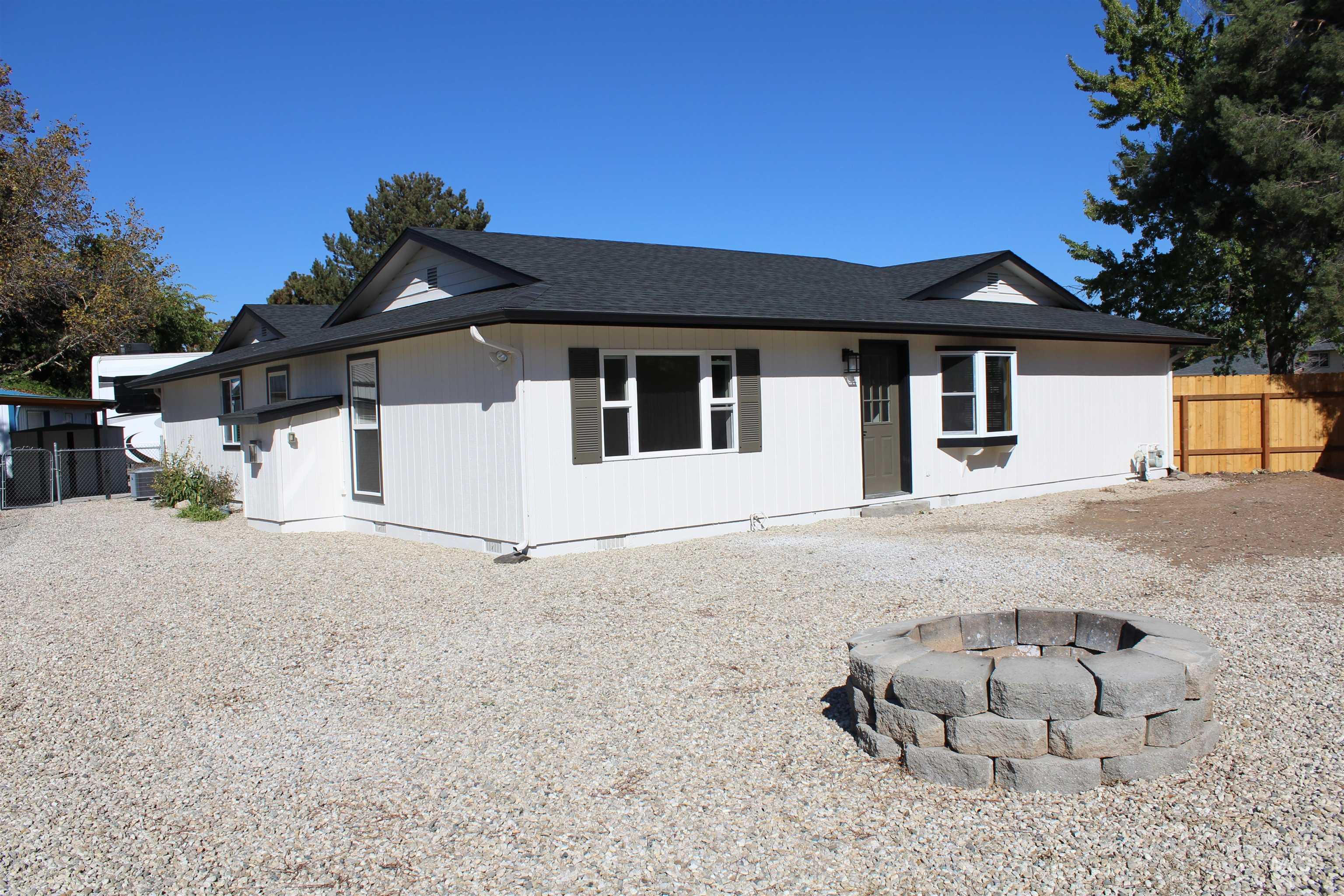 Single story home featuring an outdoor fire pit, a shingled roof, and crawl space