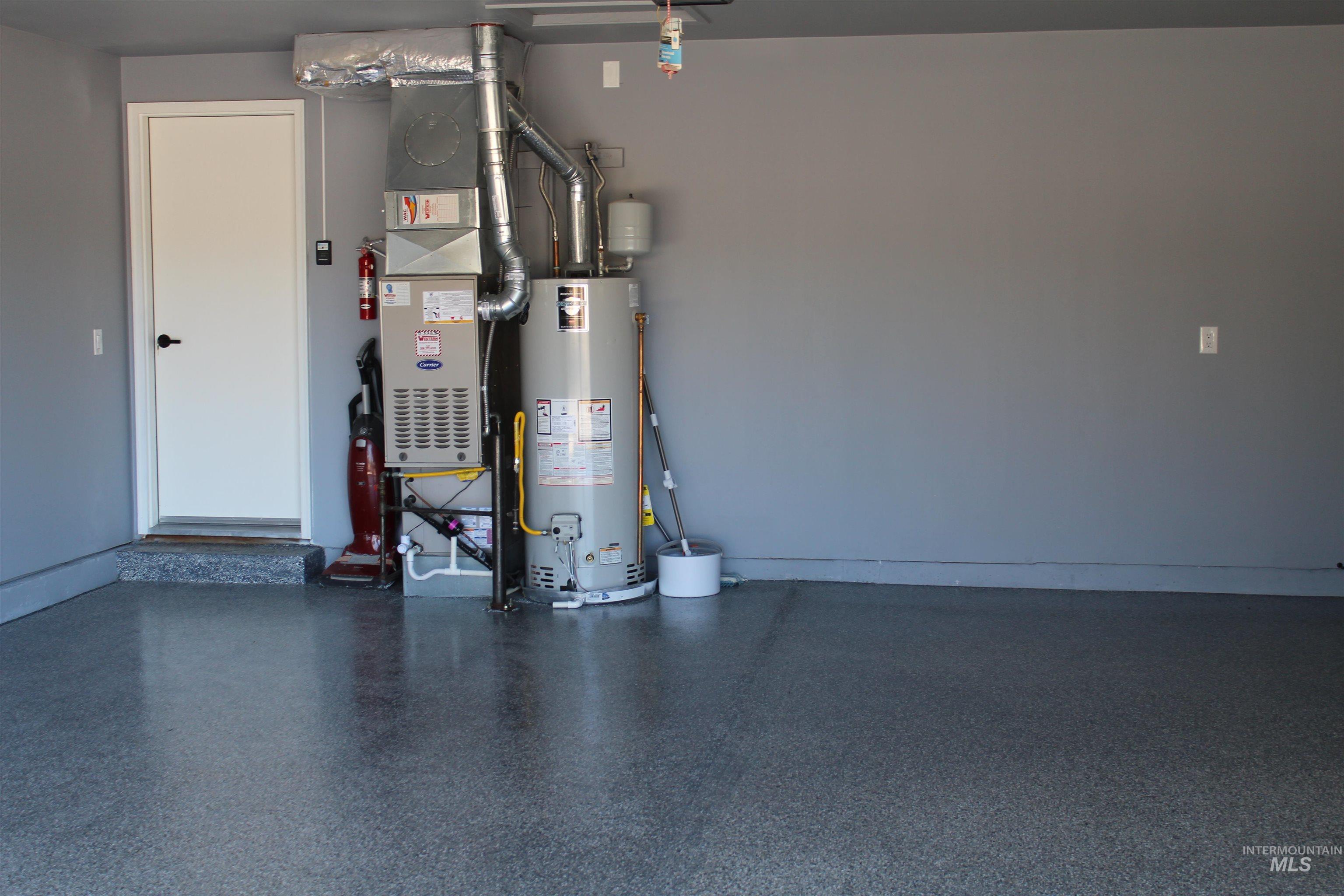 Garage featuring water heater and heating unit