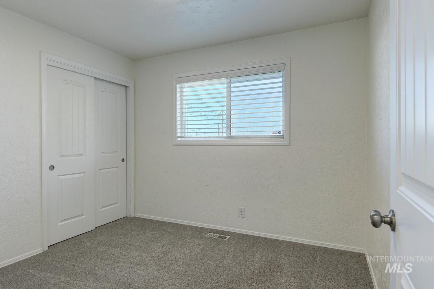 Unfurnished bedroom featuring carpet, a closet, and a textured wall