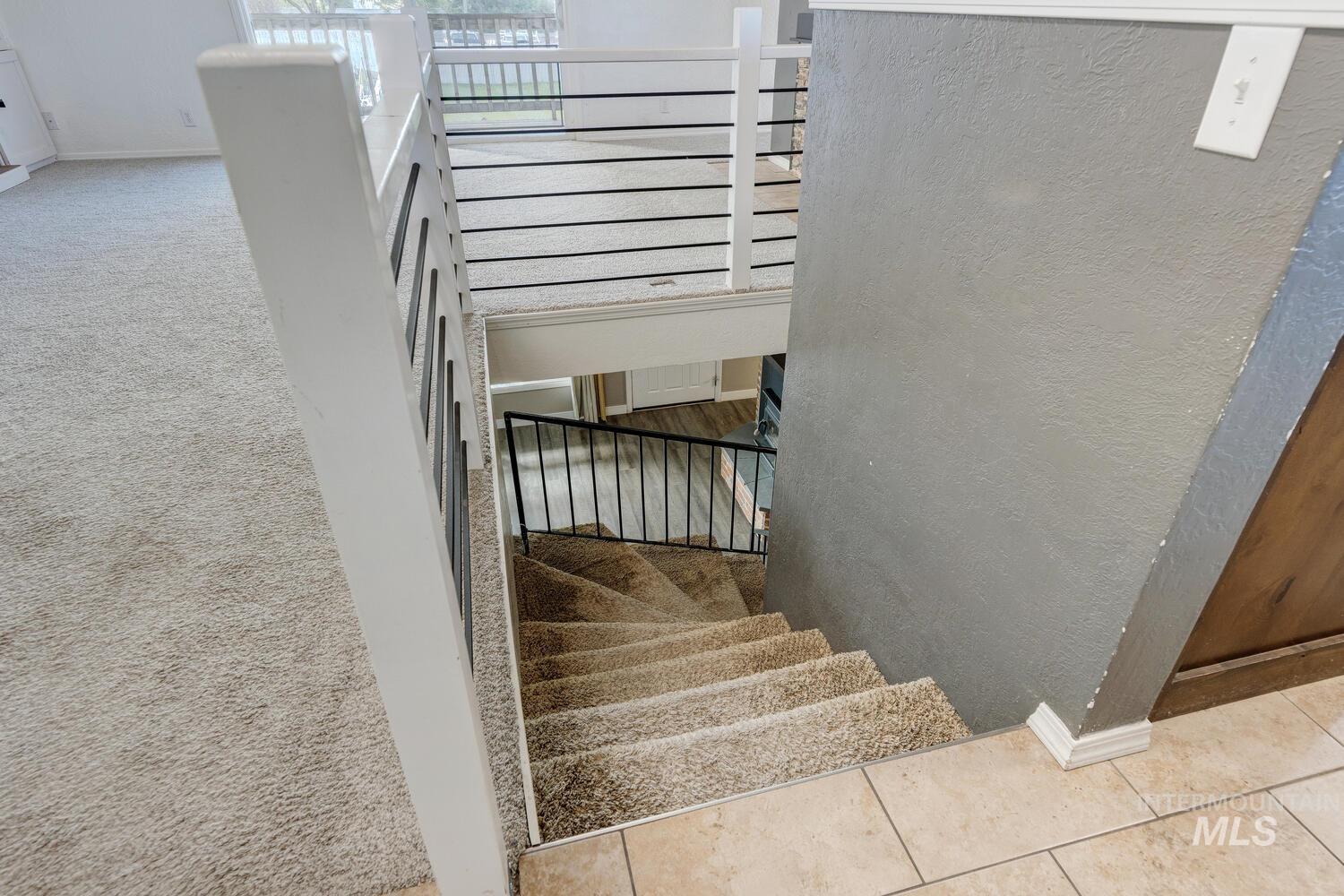 Stairway featuring a textured wall and tile patterned floors