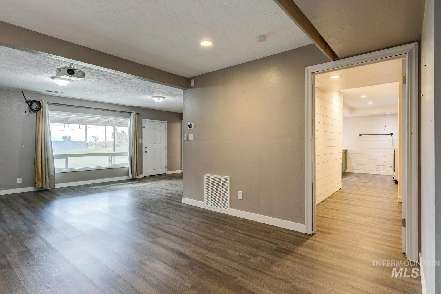 Spare room with wood finished floors and a textured ceiling
