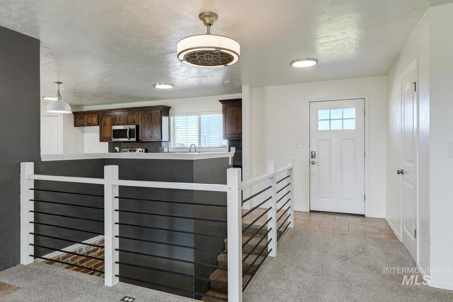 Entryway with light carpet and a textured ceiling