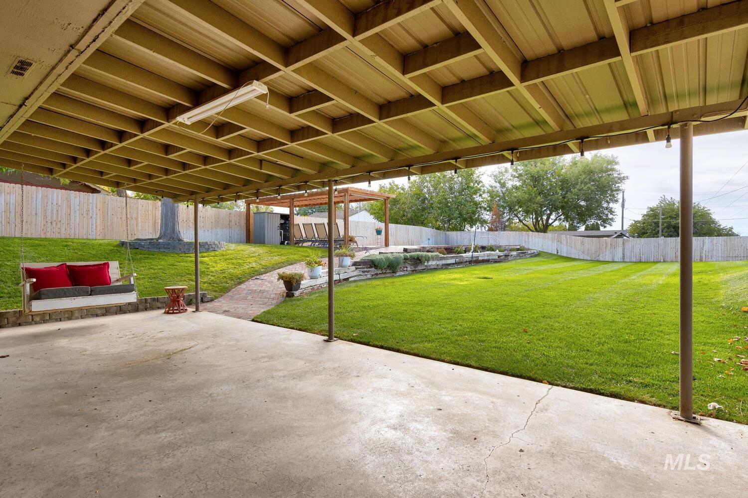 Fenced backyard with a patio and an outbuilding