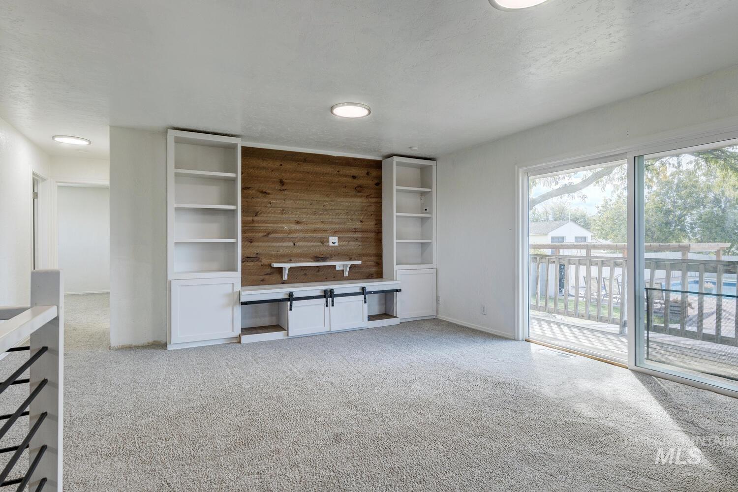 Unfurnished living room featuring light colored carpet and a textured ceiling