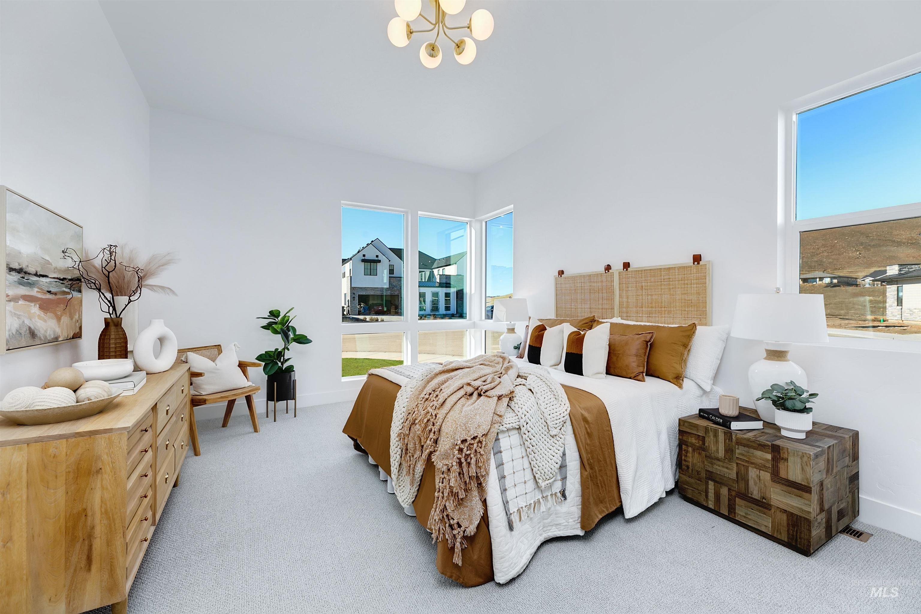 Bedroom with light carpet, multiple windows, and a chandelier