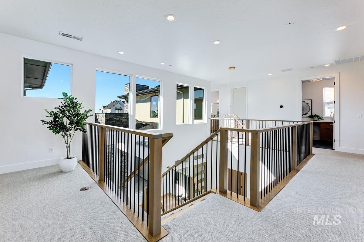 Hall featuring carpet, healthy amount of natural light, an upstairs landing, and recessed lighting