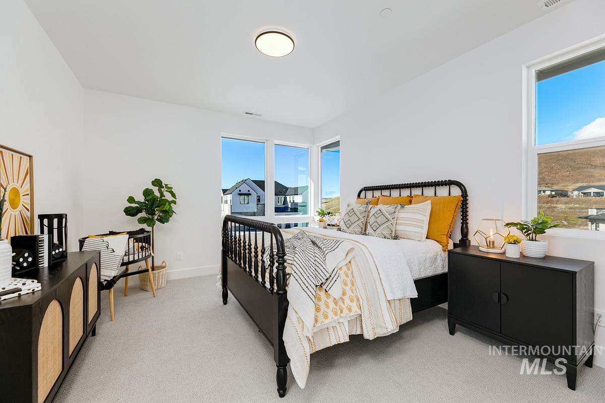 Bedroom with light colored carpet and baseboards