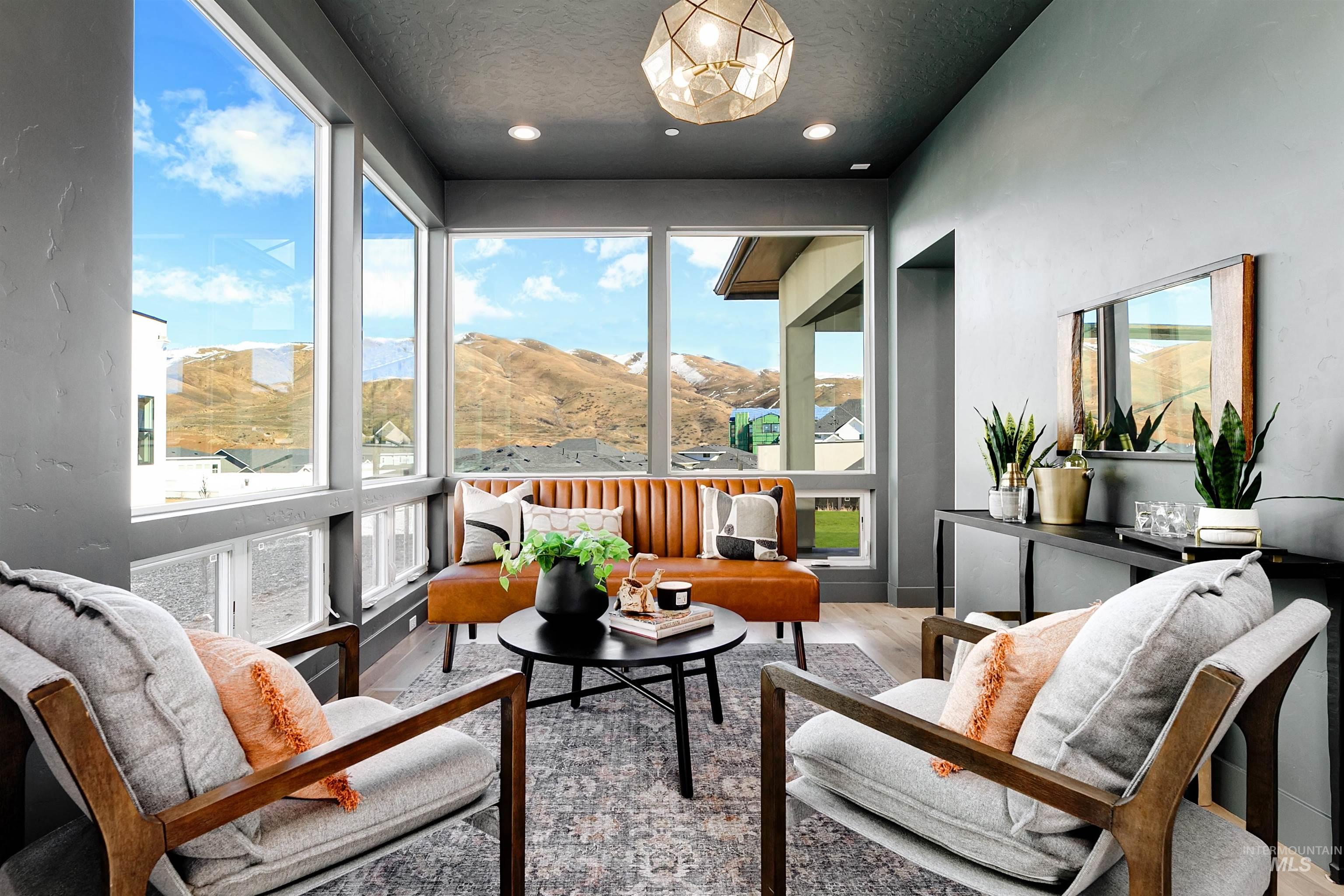 Sunroom / solarium featuring a mountain view, healthy amount of natural light, wood finished floors, a textured ceiling, and recessed lighting