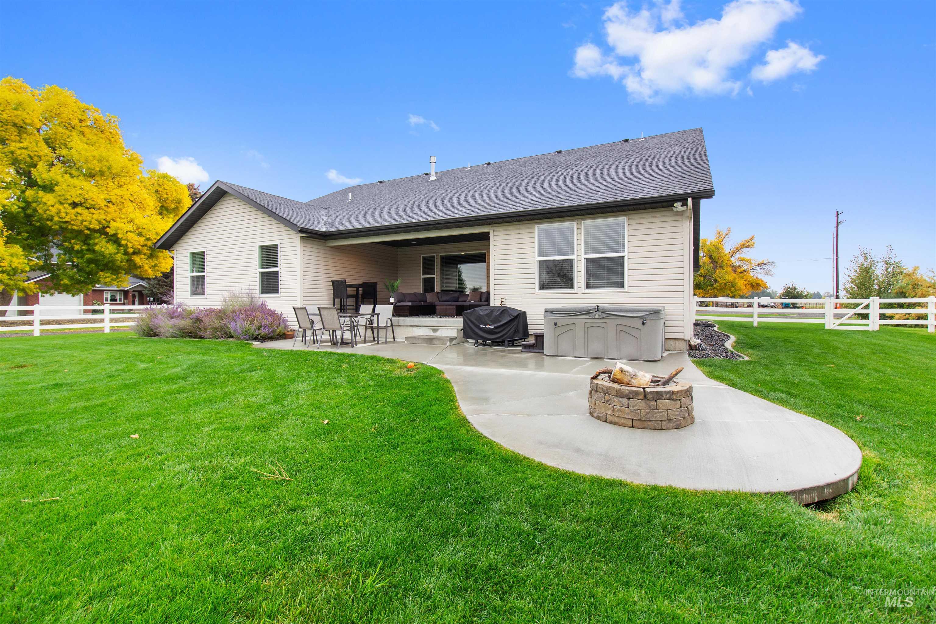Back of property featuring a fenced backyard, a patio, an outdoor fire pit, and a shingled roof