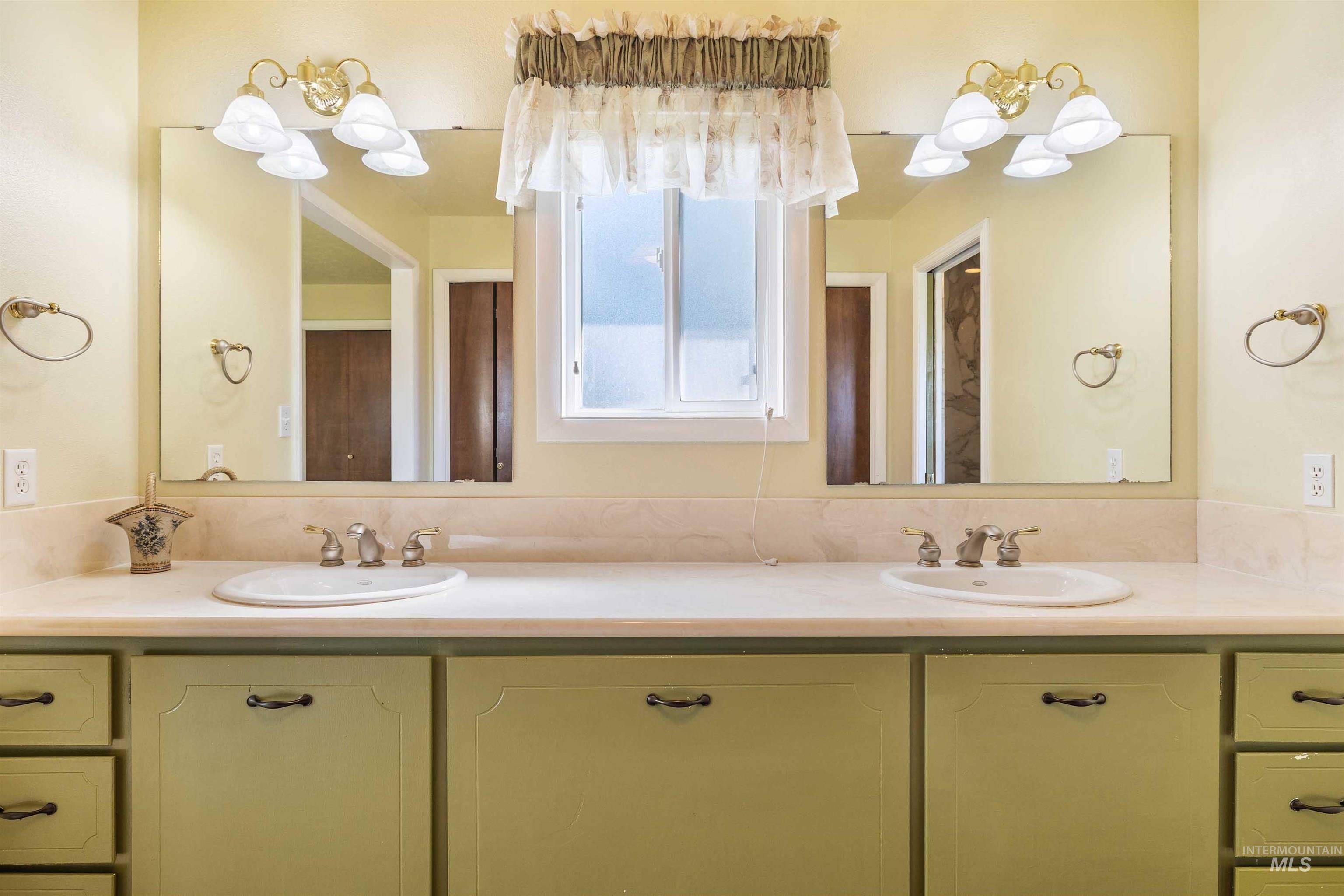 Bathroom featuring double vanity and a chandelier