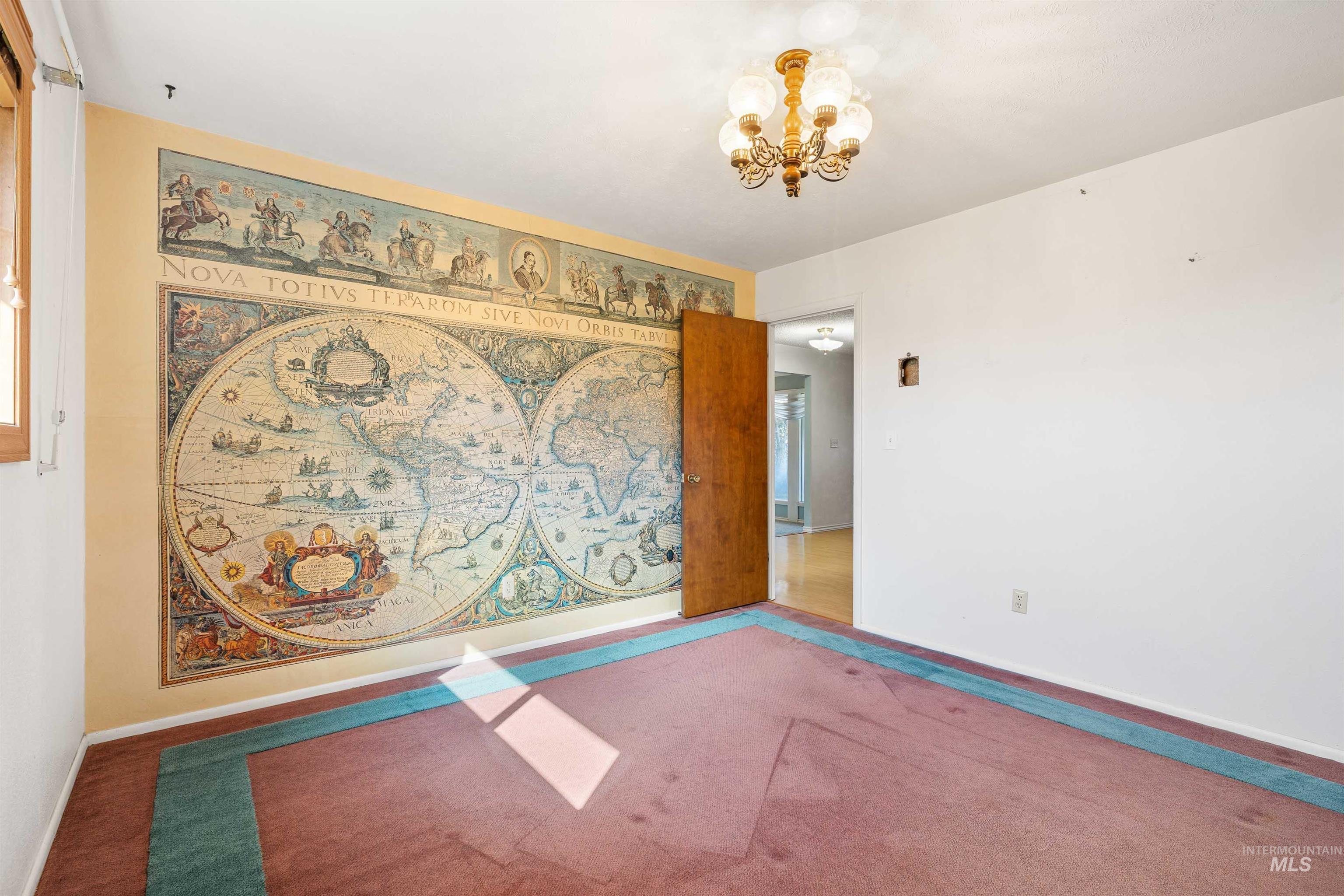 Unfurnished room with a chandelier and carpet flooring