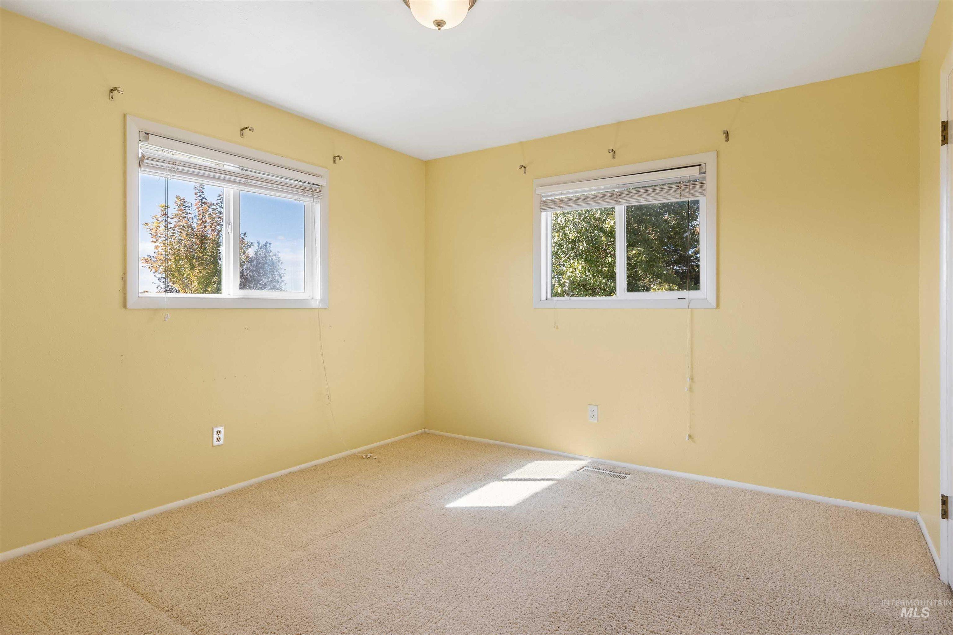 Unfurnished room featuring carpet floors and healthy amount of natural light