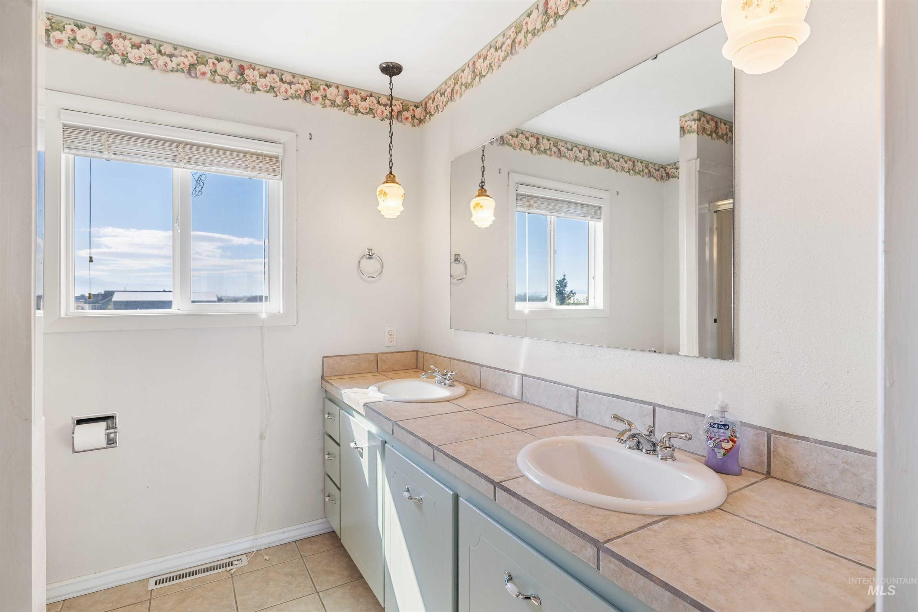 Bathroom featuring double vanity and light tile patterned floors
