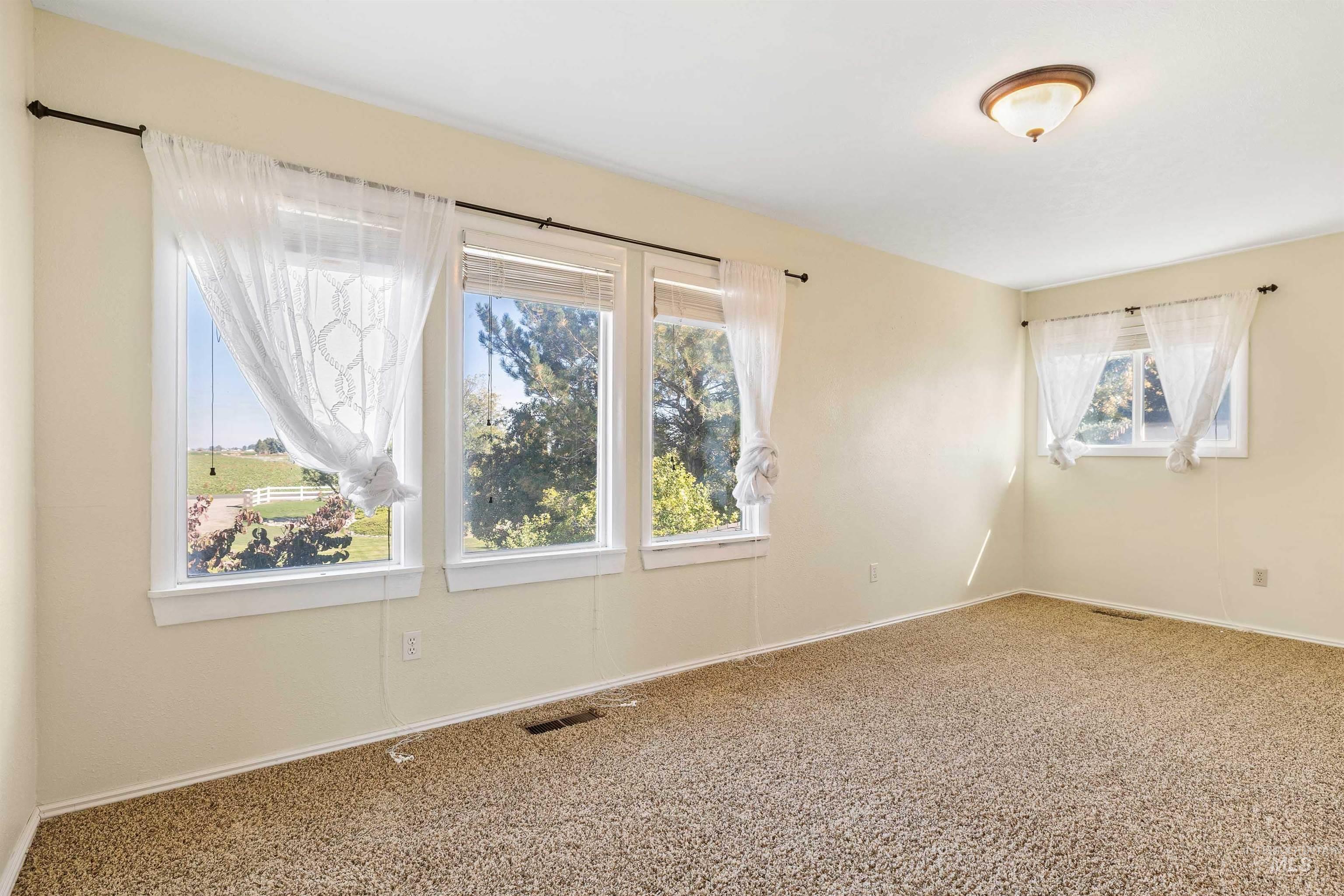 Empty room featuring baseboards and carpet