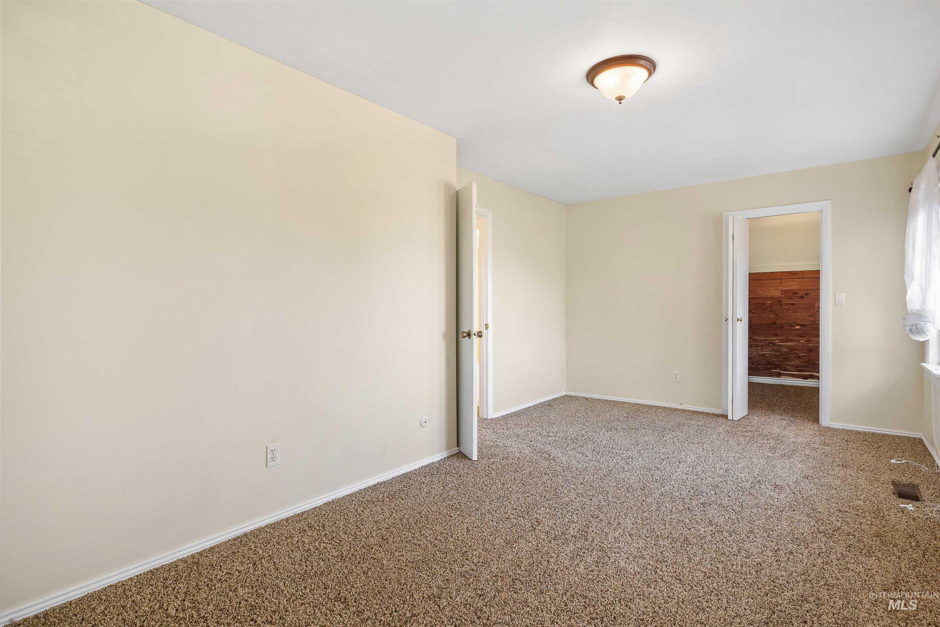 Empty room featuring carpet and baseboards