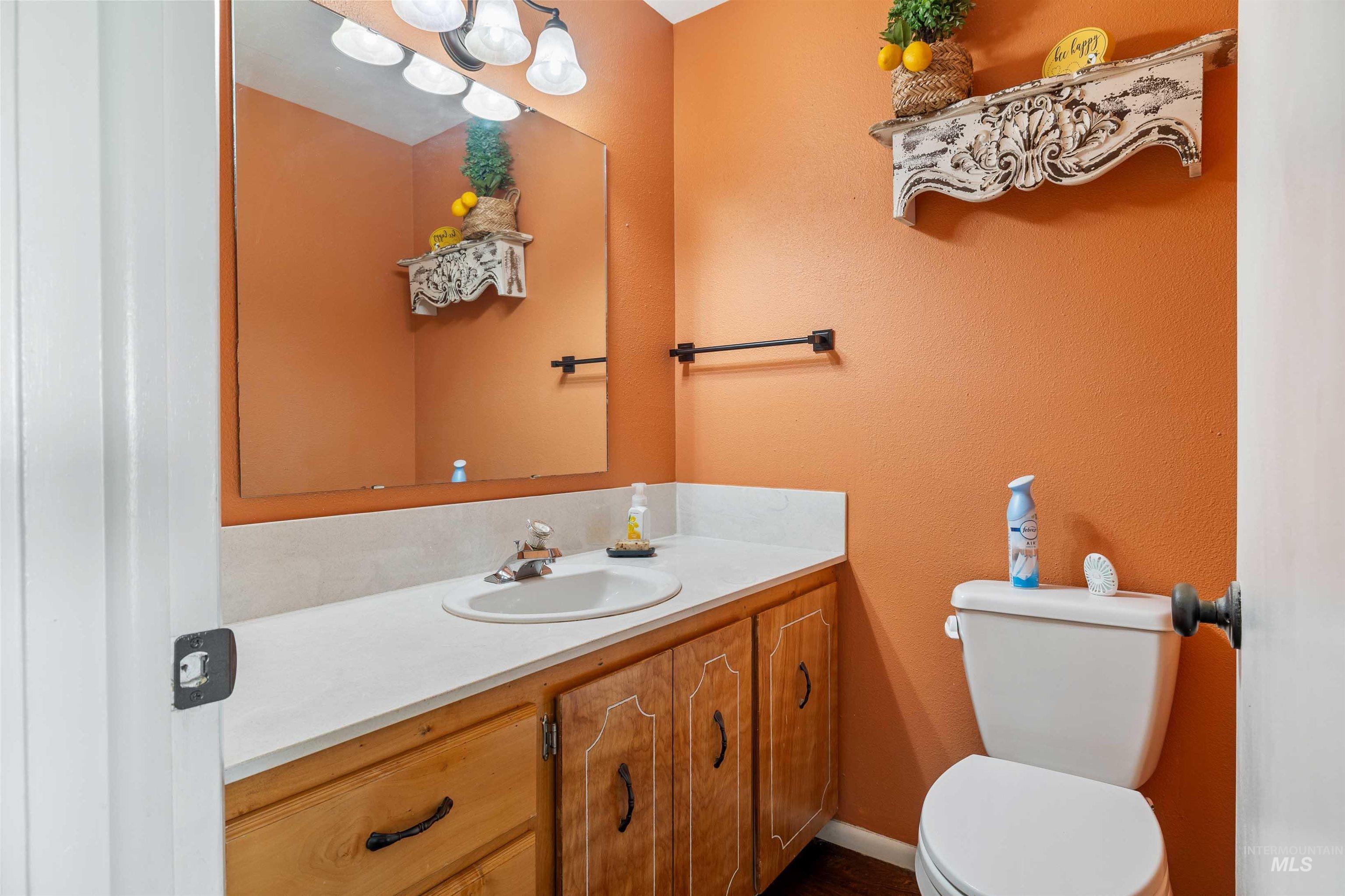 Half bathroom featuring vanity and a textured wall