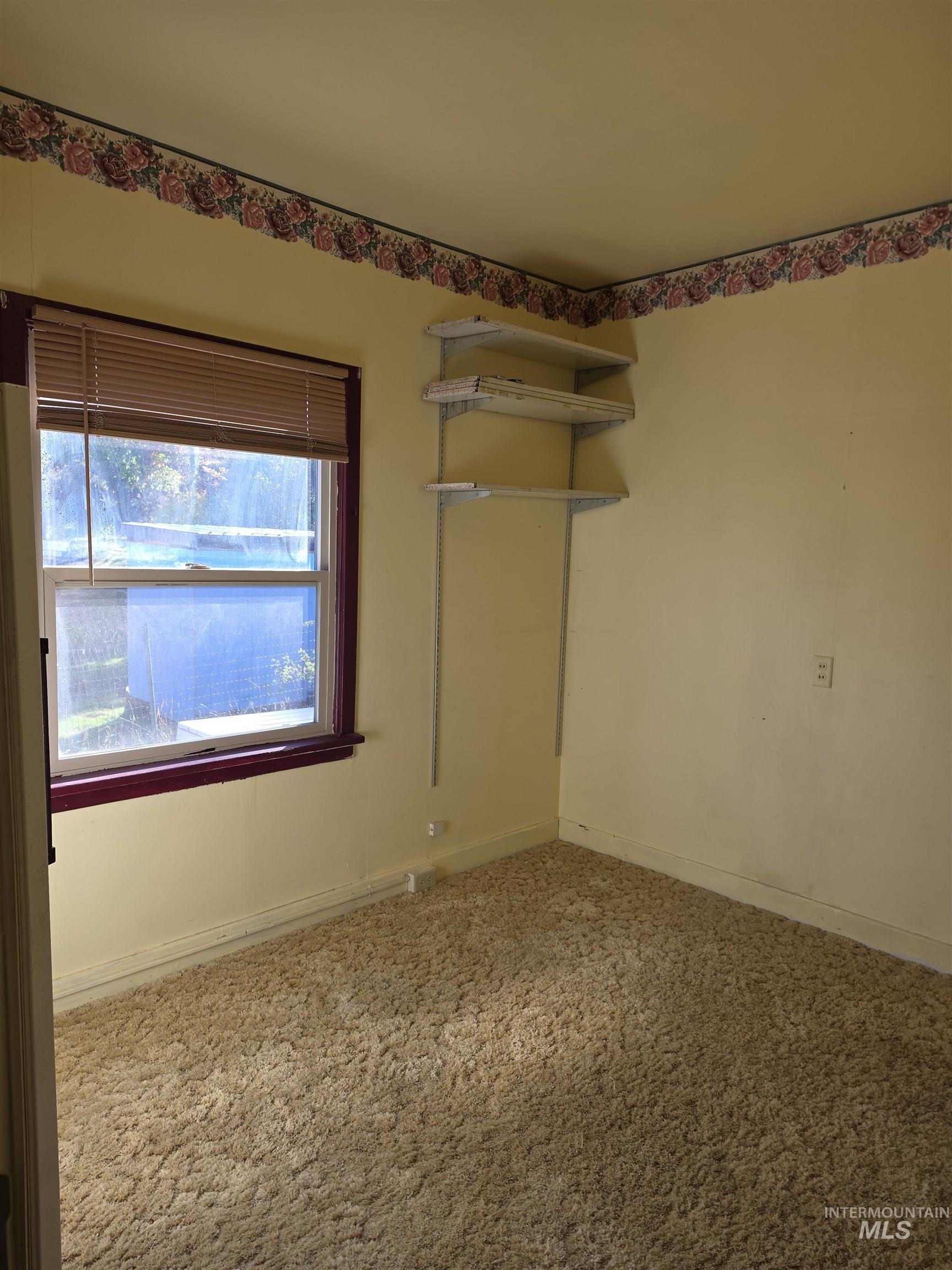 Spare room featuring light carpet and baseboards