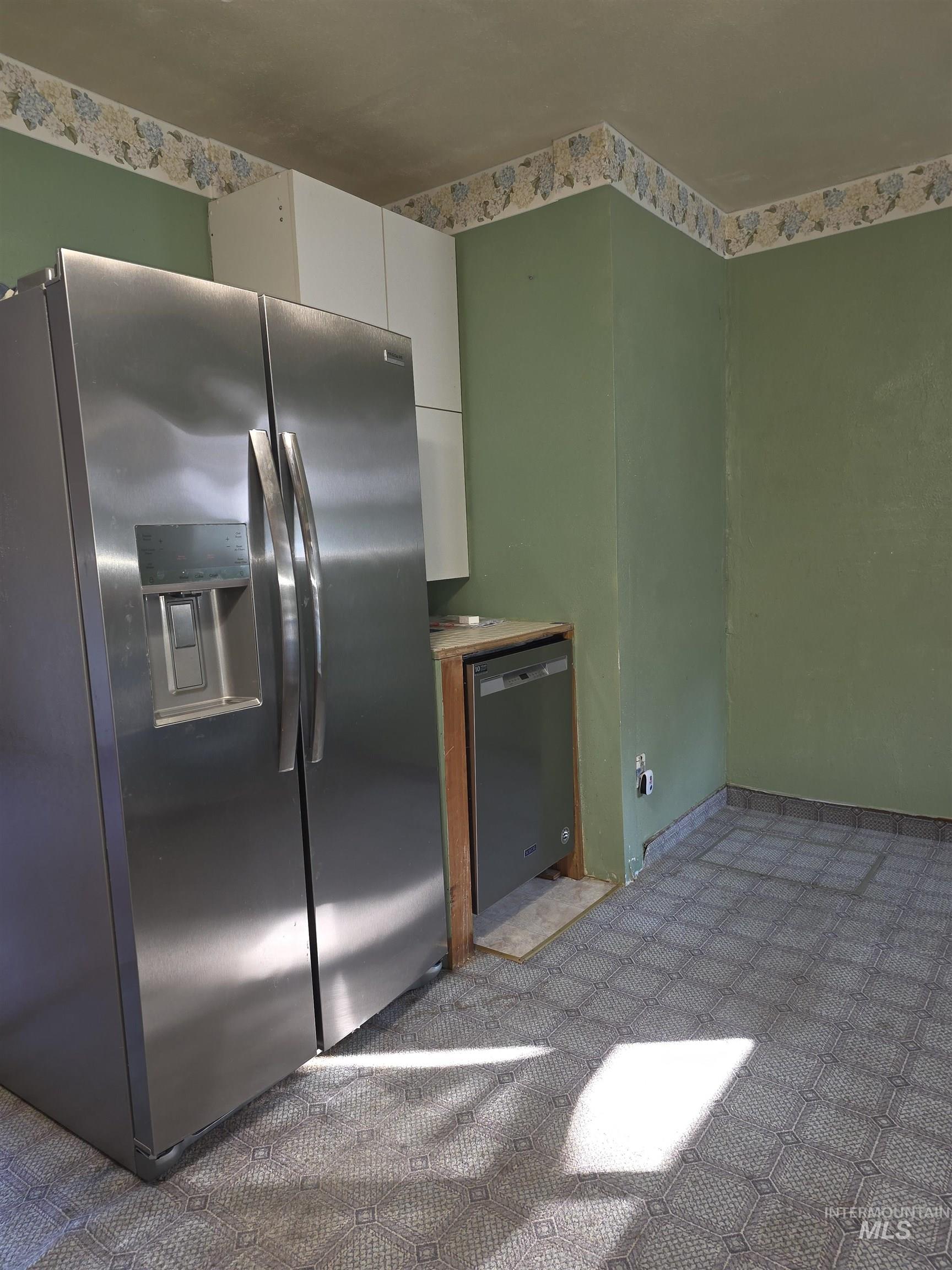 Kitchen with appliances with stainless steel finishes, carpet, and white cabinetry