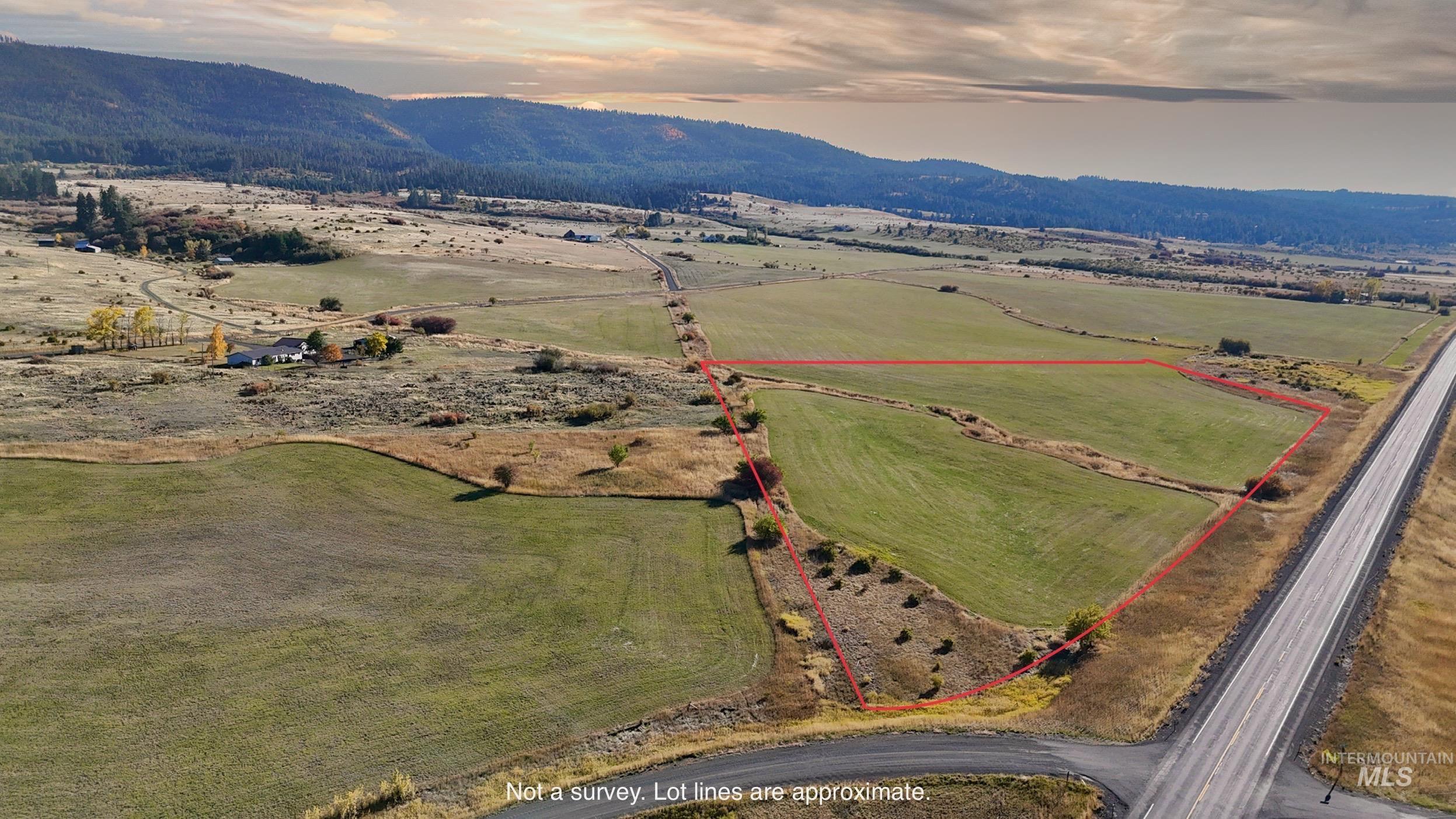 Aerial view at dusk of property parcel outlined, a rural view, and a mountain view