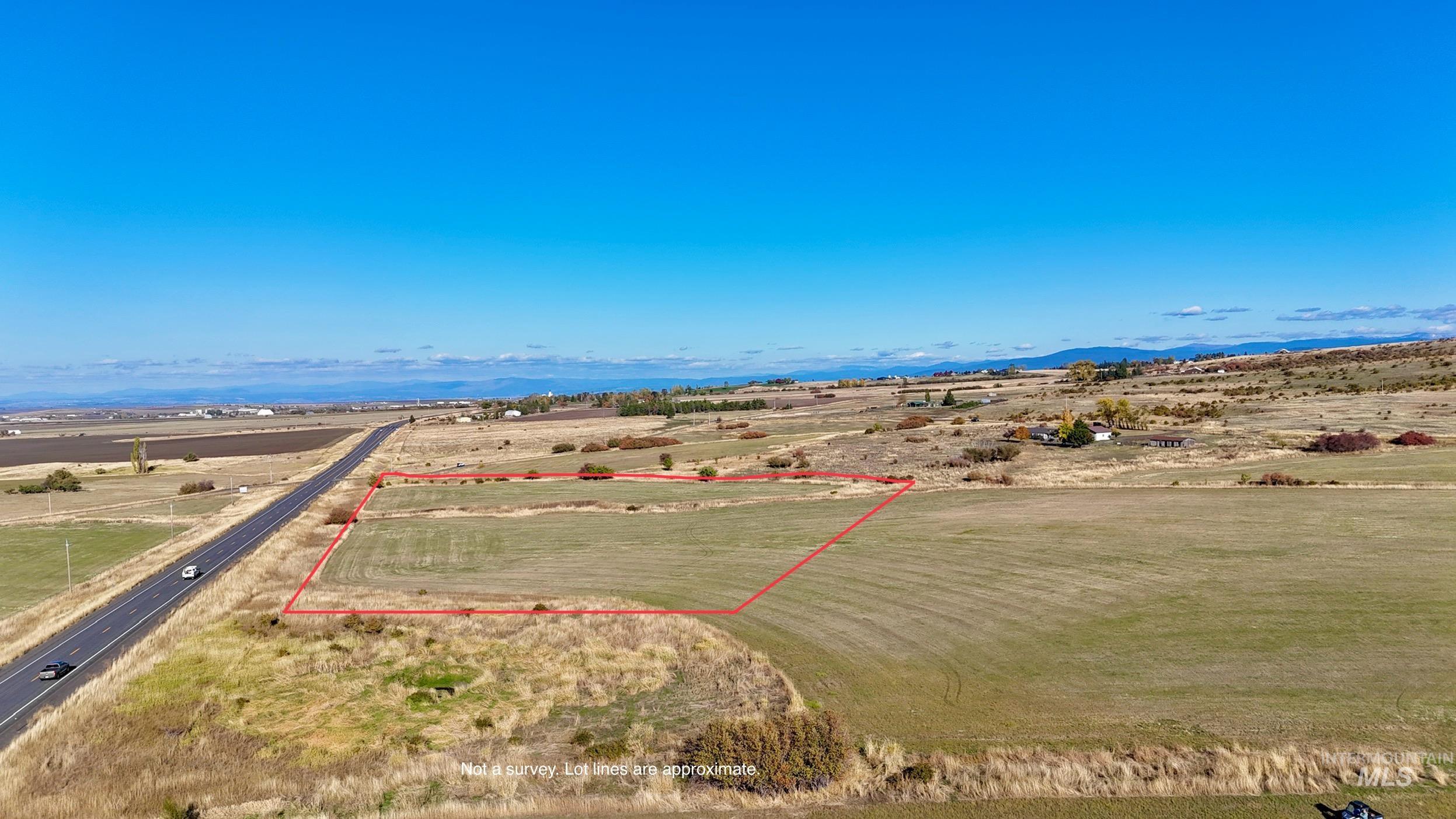 Aerial view of sparsely populated area with property boundaries highlighted and a mountain backdrop
