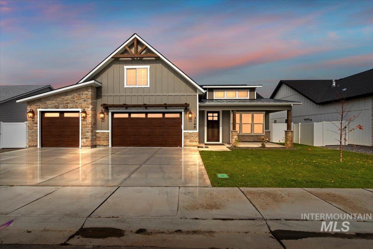 View of front of home with board and batten siding, a porch, concrete driveway, and stone siding