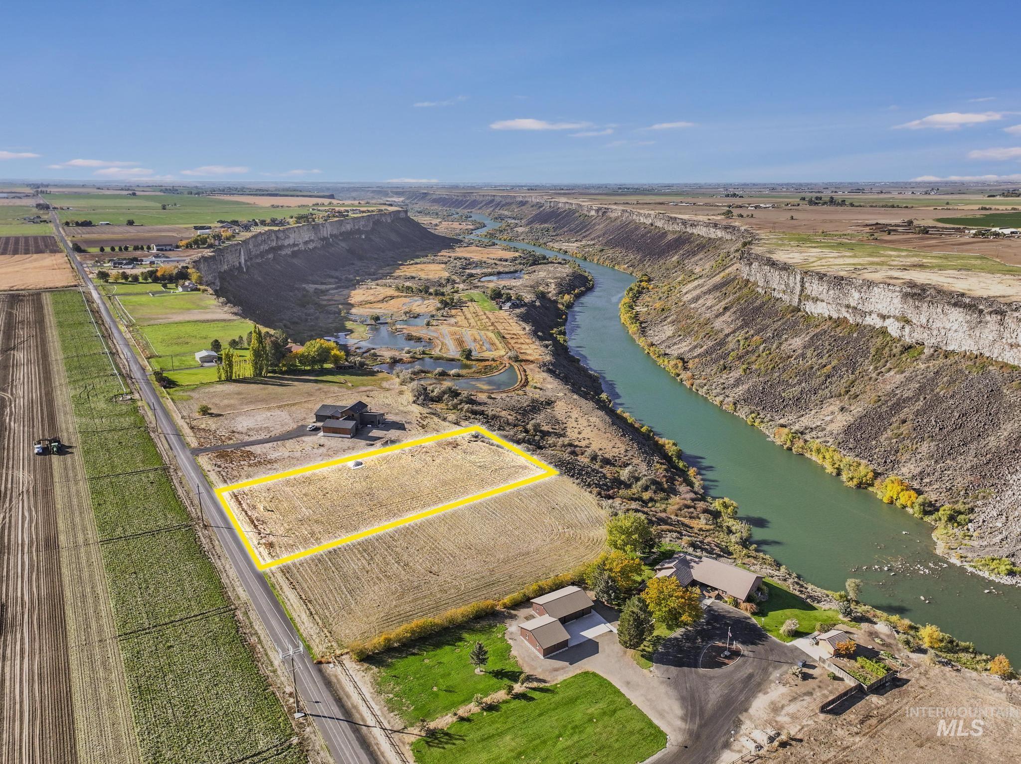 Aerial view of sparsely populated area with property boundaries highlighted, farmland, and a nearby body of water