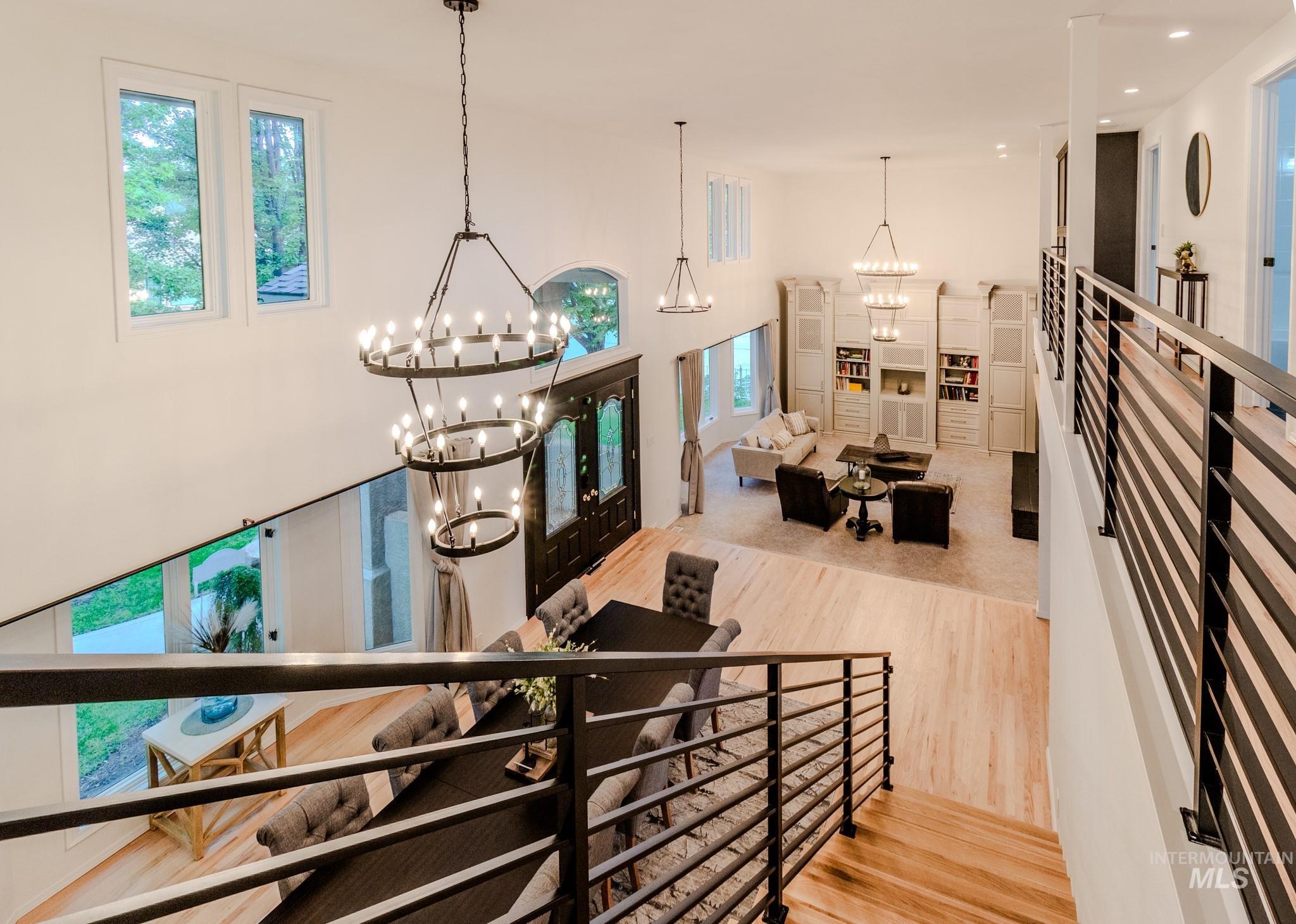 Stairway with wood finished floors, plenty of natural light, a chandelier, french doors, and recessed lighting