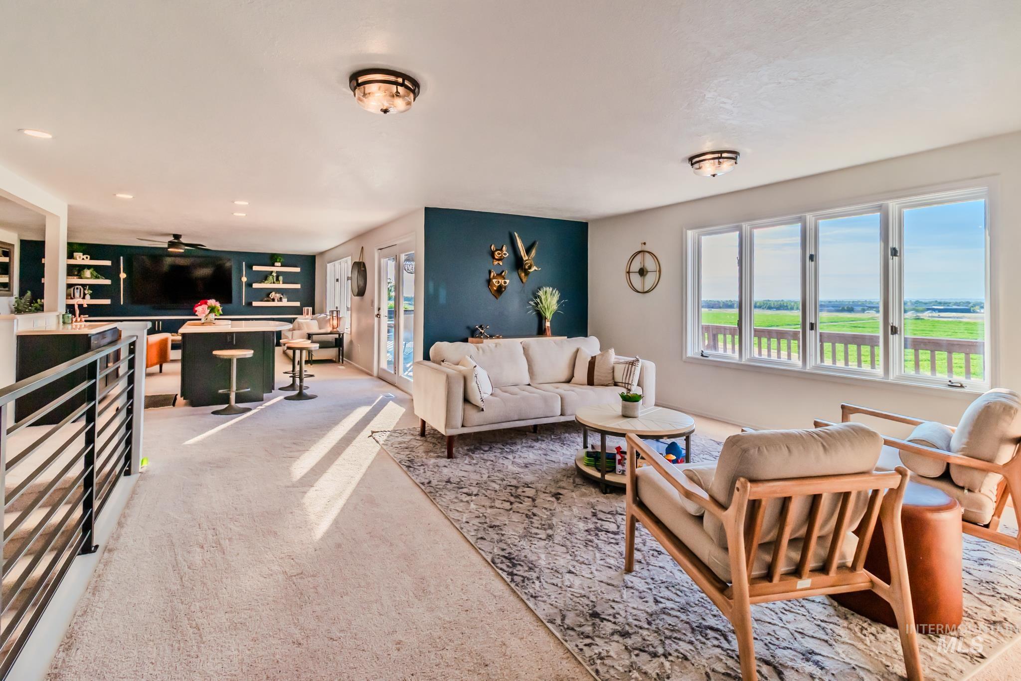 Living room with plenty of natural light, light colored carpet, and a ceiling fan