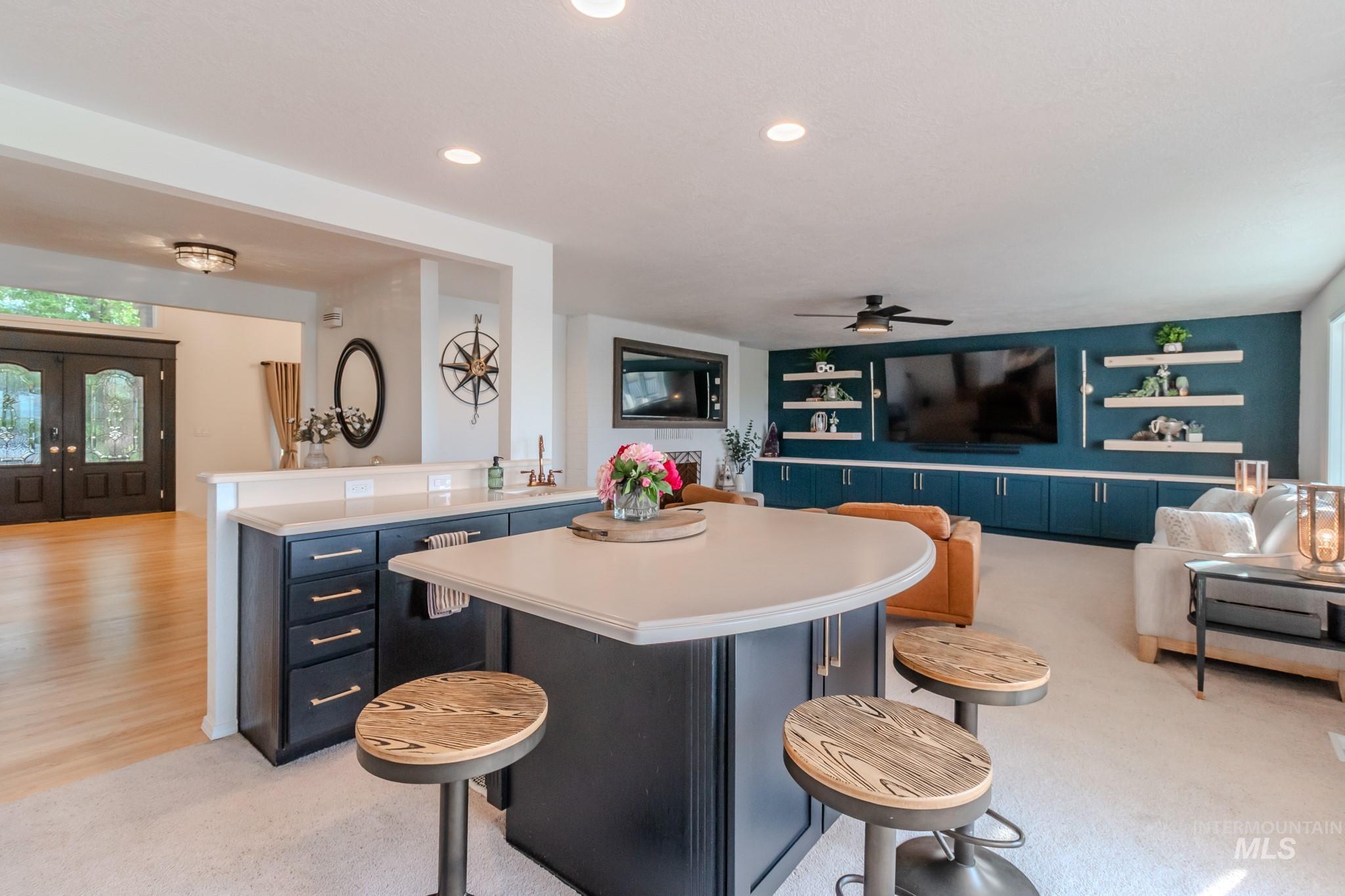 Kitchen with open floor plan, blue cabinets, light countertops, a ceiling fan, and recessed lighting