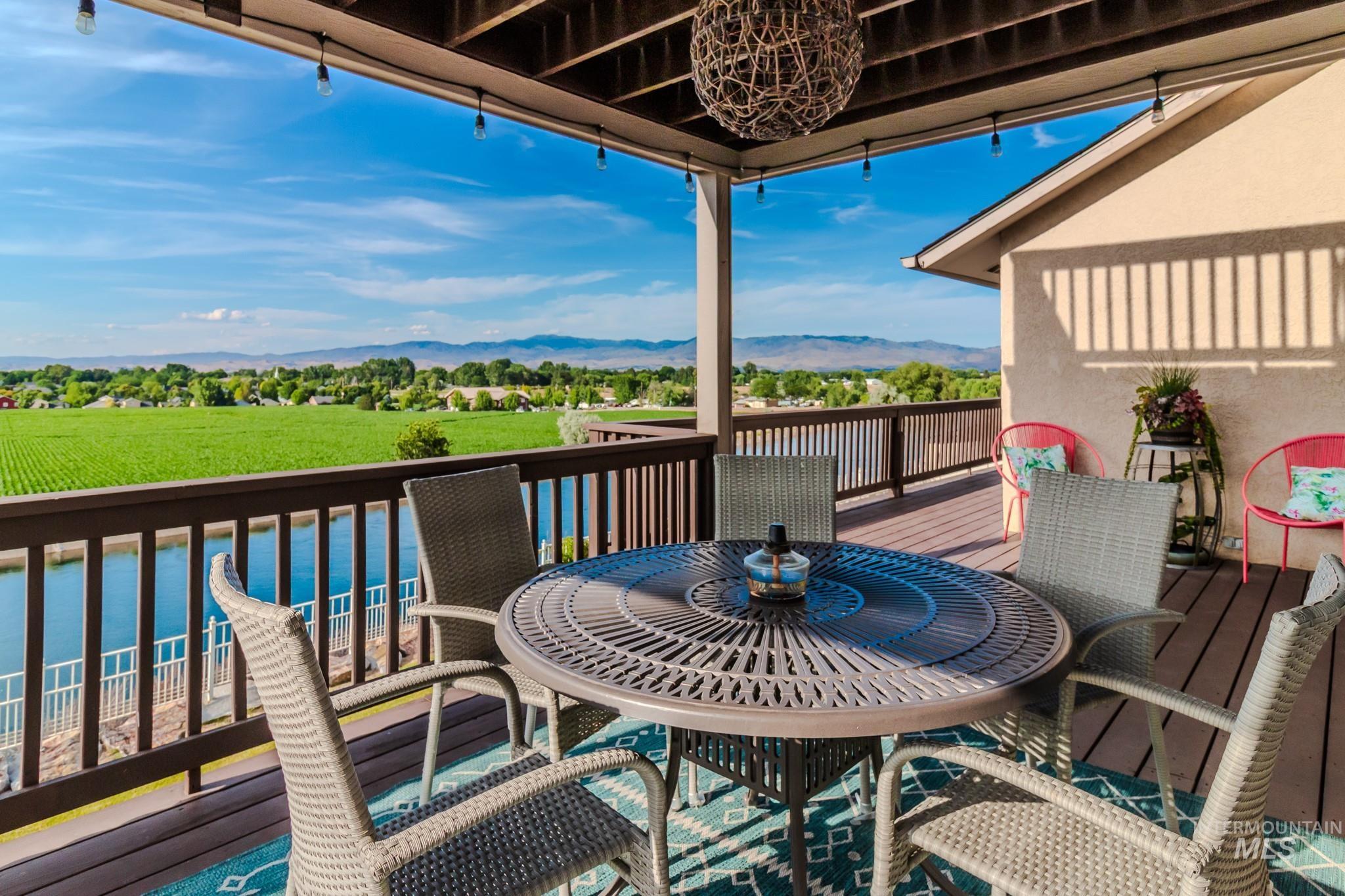 Wooden terrace featuring a mountain view and outdoor dining area