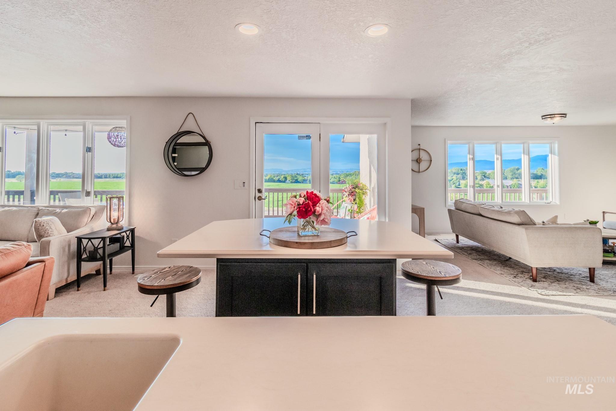 Dining room with light carpet, a textured ceiling, and recessed lighting