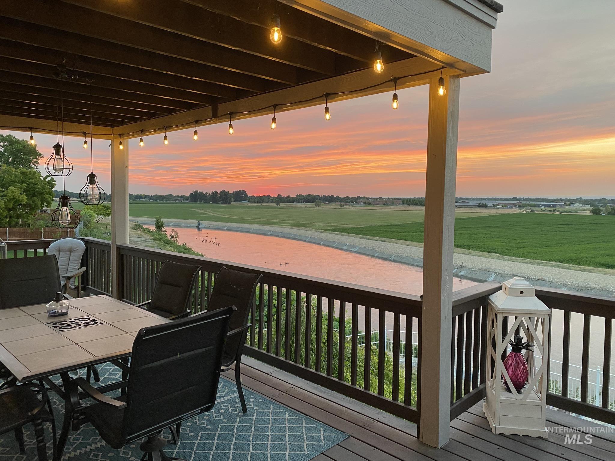 Wooden deck with a water view and outdoor dining area