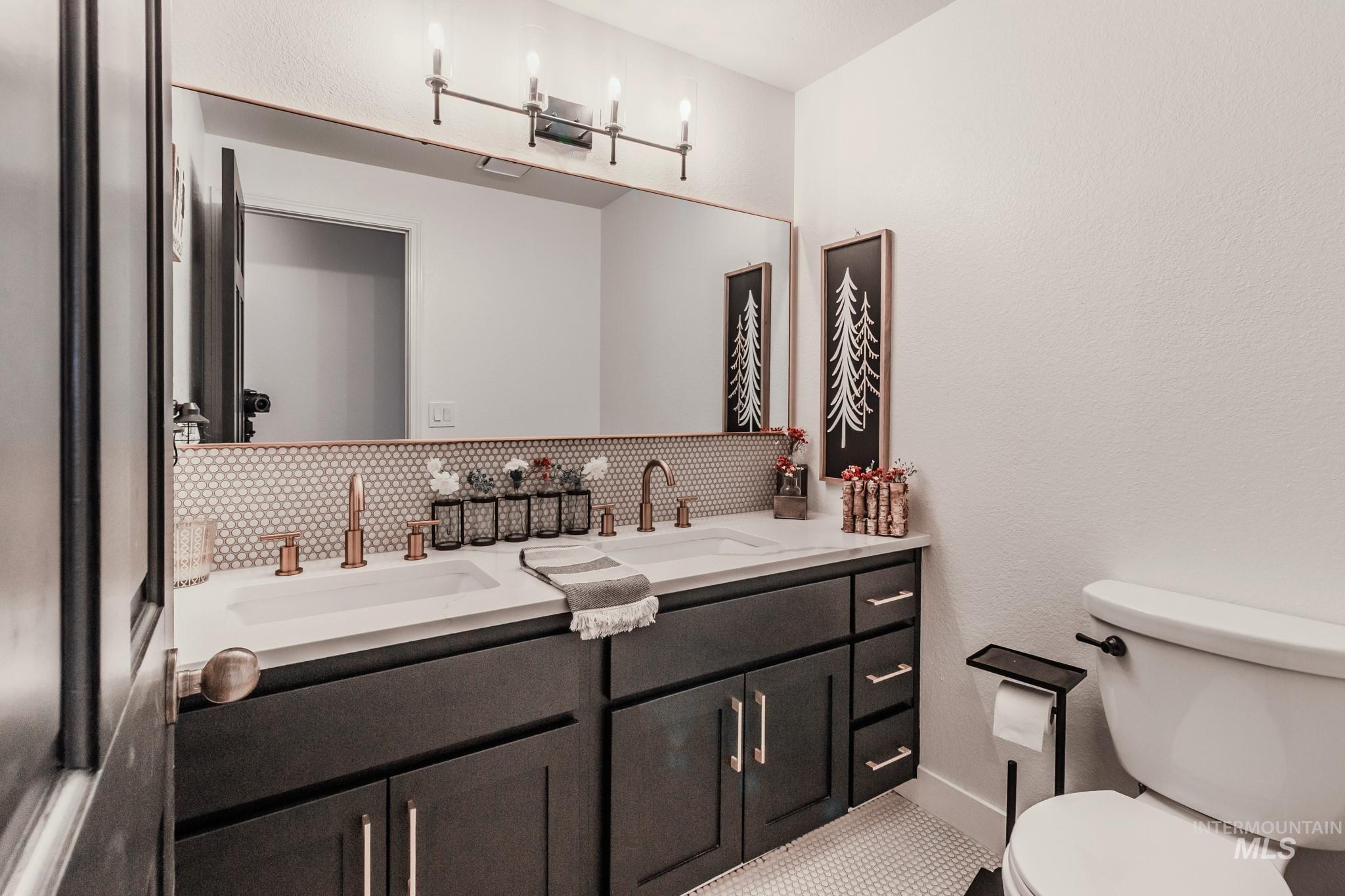 Bathroom with double vanity and tasteful backsplash