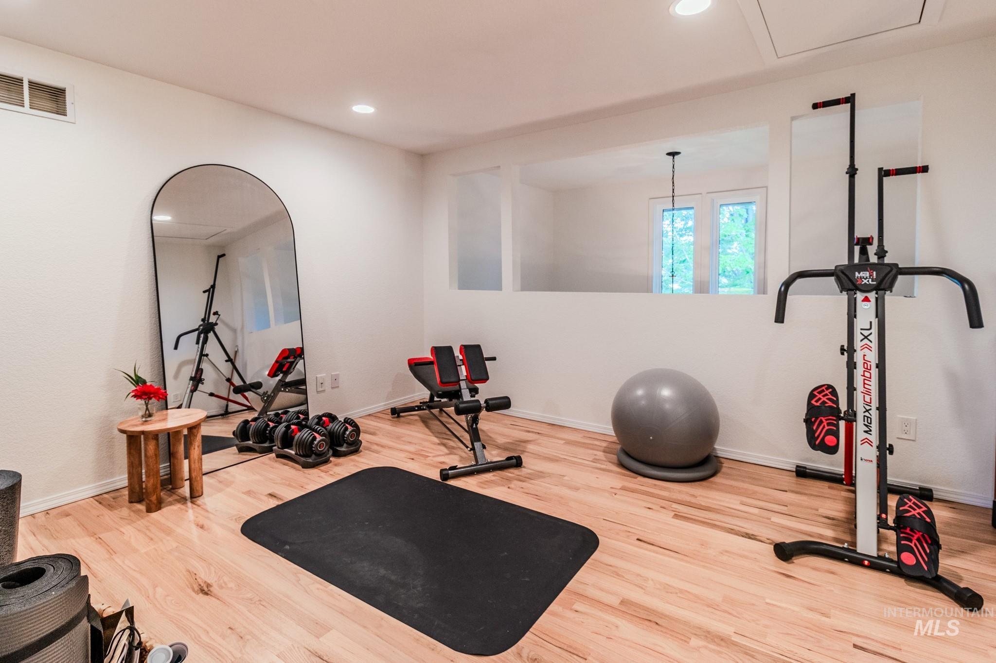 Exercise room featuring wood finished floors and recessed lighting