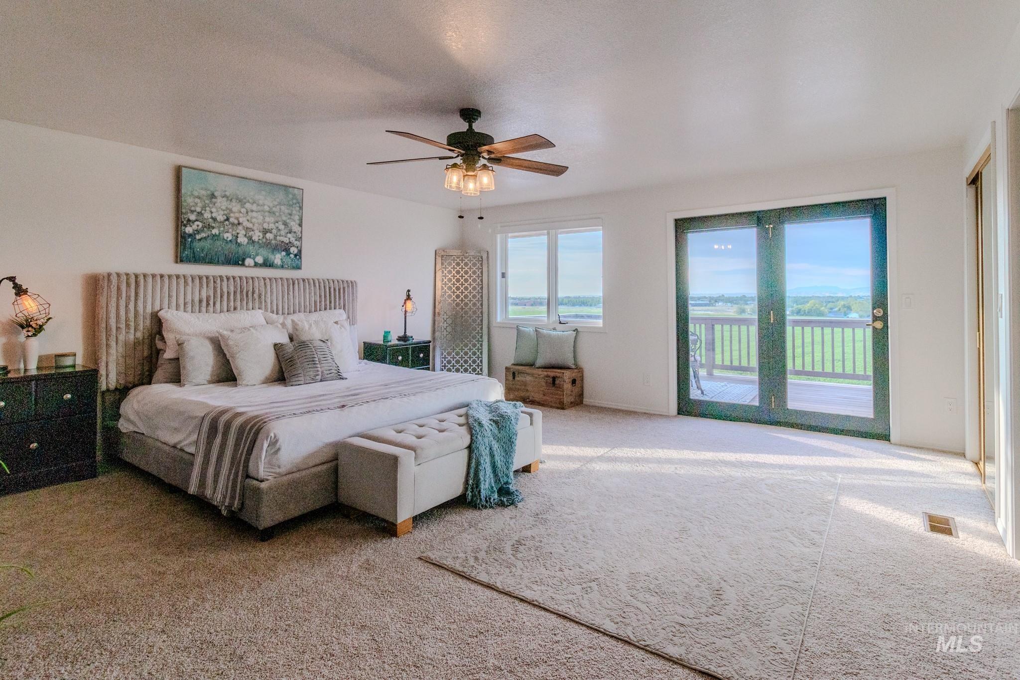 Bedroom with access to exterior, carpet flooring, and a ceiling fan