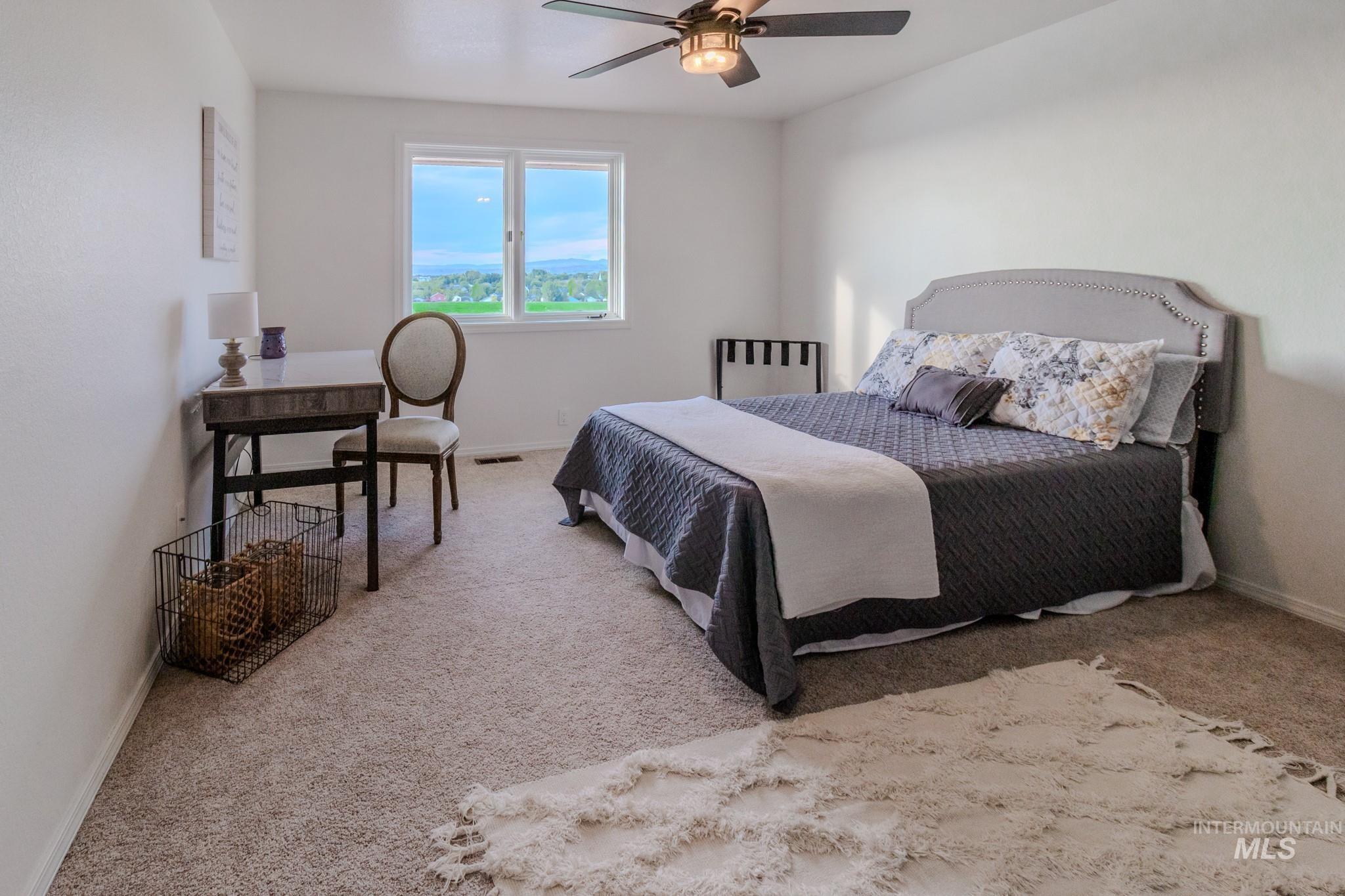 Carpeted bedroom featuring baseboards and a ceiling fan