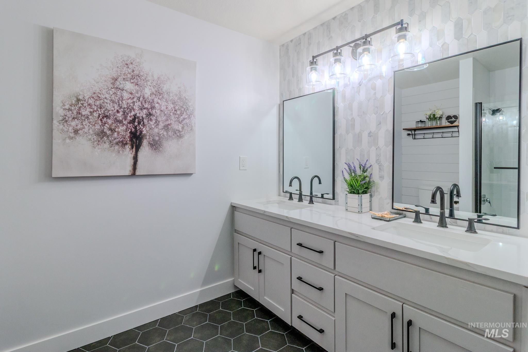 Full bath featuring tile patterned flooring, double vanity, and an enclosed shower
