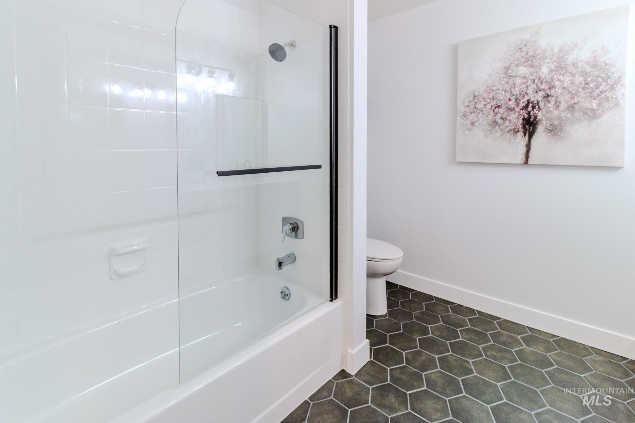 Bathroom with shower / washtub combination and tile patterned floors